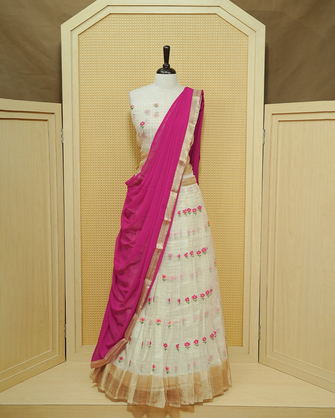Cream colour Semi stitched Dhavani set featuring Gold zari checked pattern with floral motifs on skirt with traditional border, comes with contrast Colour Dupatta & matching blouse piece.