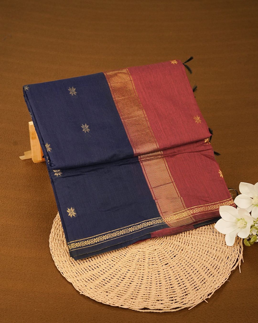 Navy Blue colour kalyani cotton saree featuring gold zari Floral pattern on body, complemented by Maroon colour with Stripes & Floral Gold zari border, paired with matching blouse piece