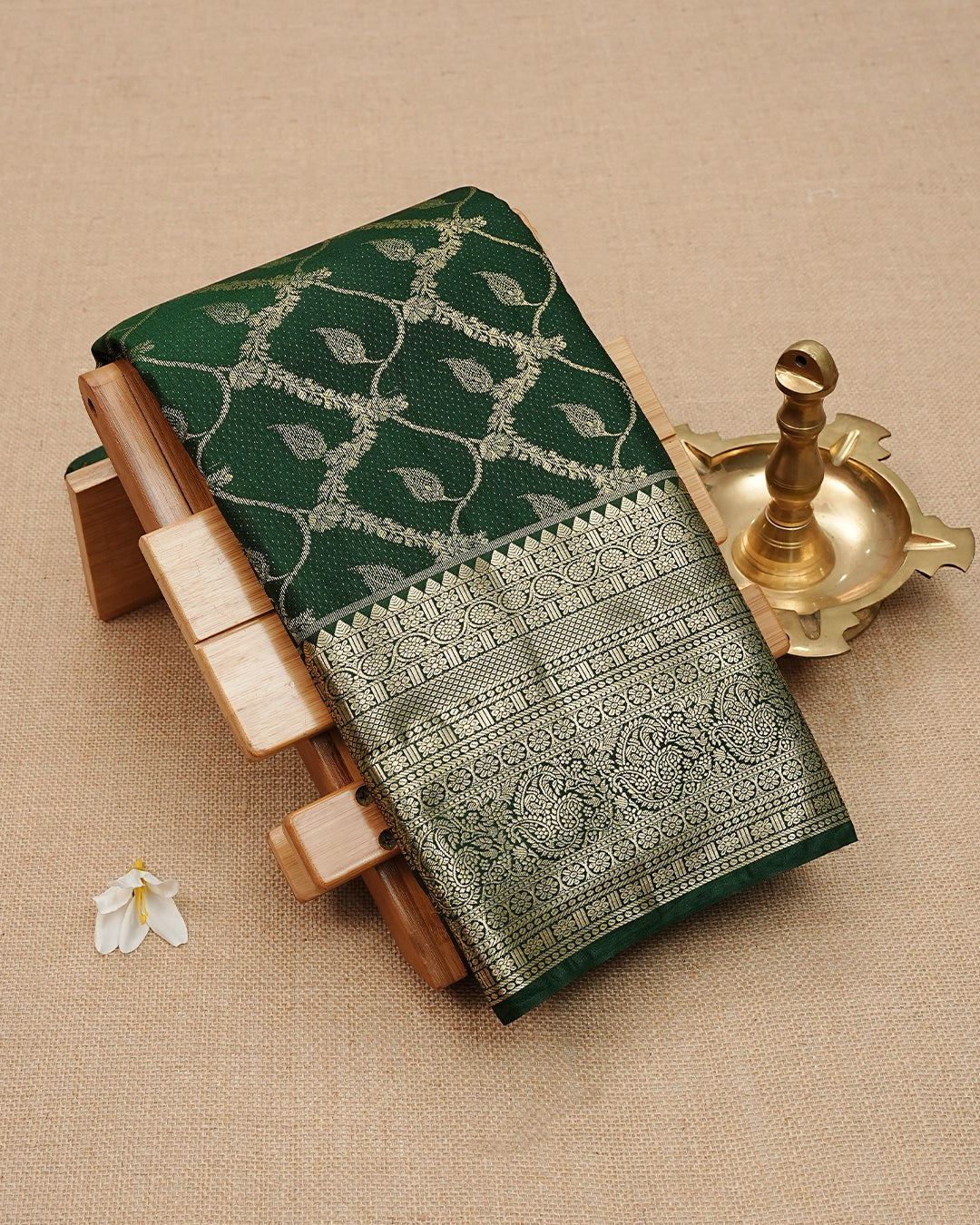 Dark Green colour semi wedding saree featuring gold zari Floral kodi Pattern on body, contrast Self colour with traditional border, paired with matching blouse piece.