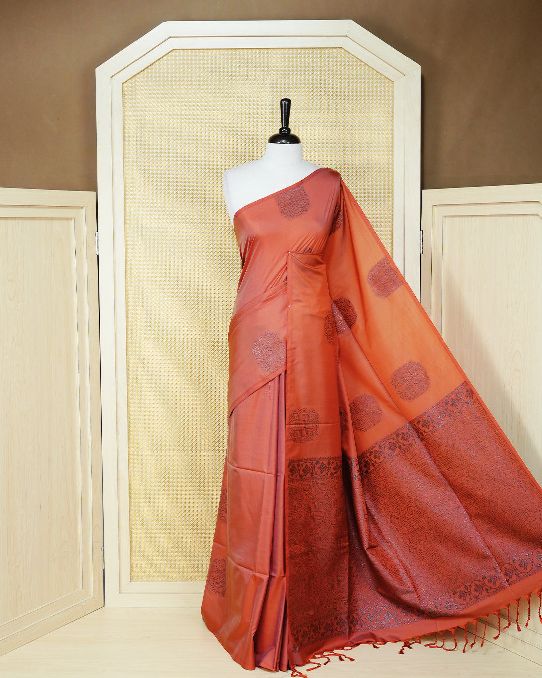 Brick orange colour soft silk saree featuring antique zari motifs on body with contrast self colour pallu & paired with matching blouse piece.