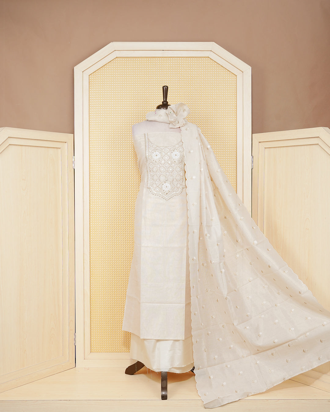 Cream colour tissue salwar material featuring elegant floral embroidery pattern adorned with Mirror and beadswork on Top, paired with matching bottom and elegant dupatta.