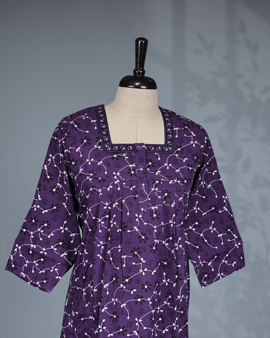 Purple colour printed nighty featuring a stylish square neckline with contrast border detailing, front button placket, soft pleated yoke, three-quarter sleeves and a relaxed full-length fit for everyday comfort and graceful style.
