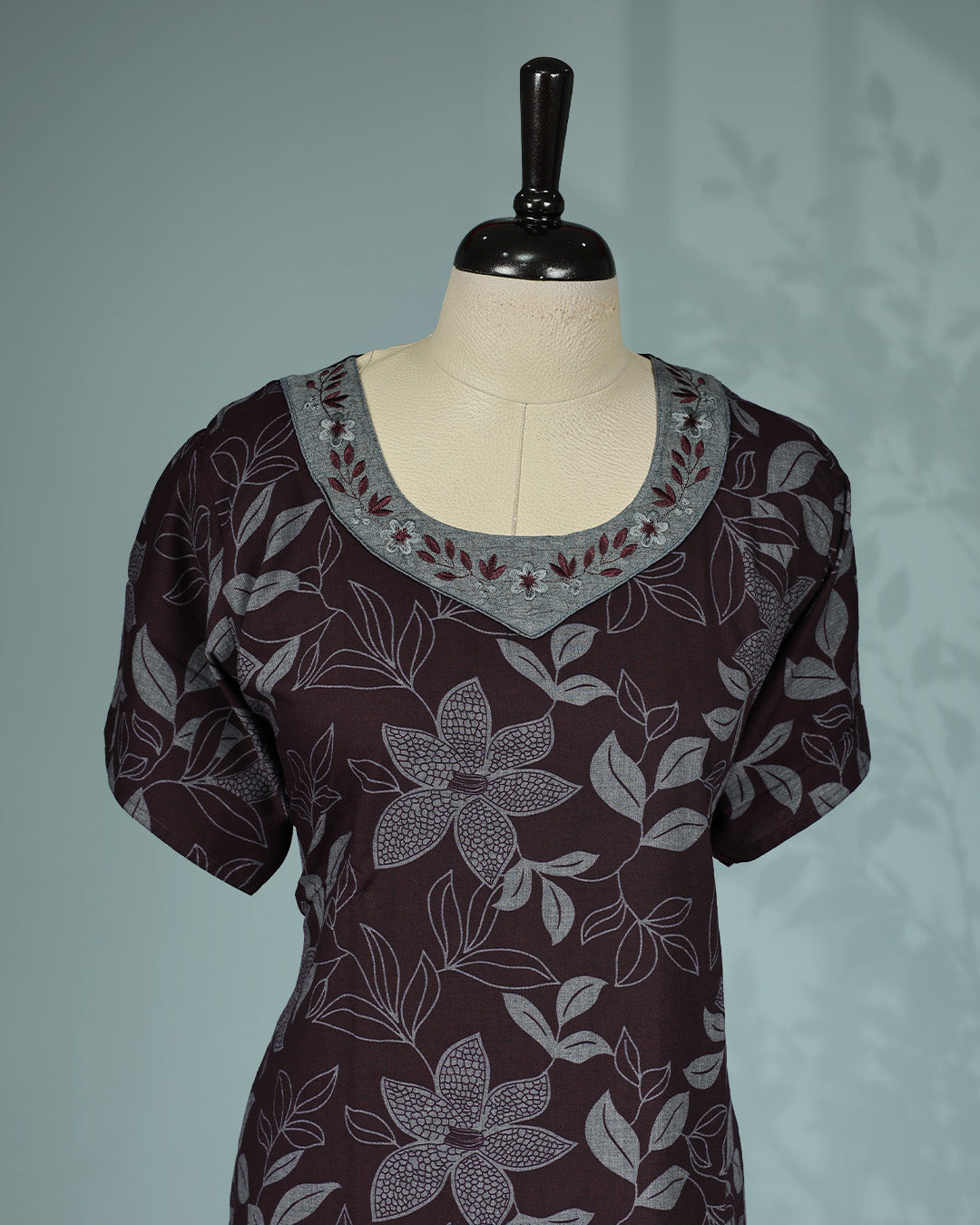 Dark brown floral kodi printed nighty featuring a round embroidered neckline with contrast grey yoke detailing, short sleeves and a comfortable ankle-length fit.