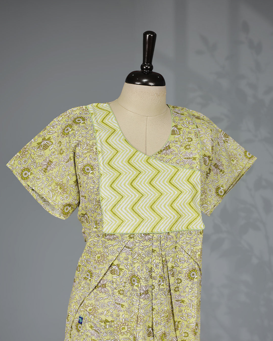 Lemon yellow floral kodi printed nighty with a stylish contrast asymmetrical zigzag yoke, V-neckline, butterfly sleeves and a relaxed full-length silhouette for breathable comfort and elegant everyday wear.