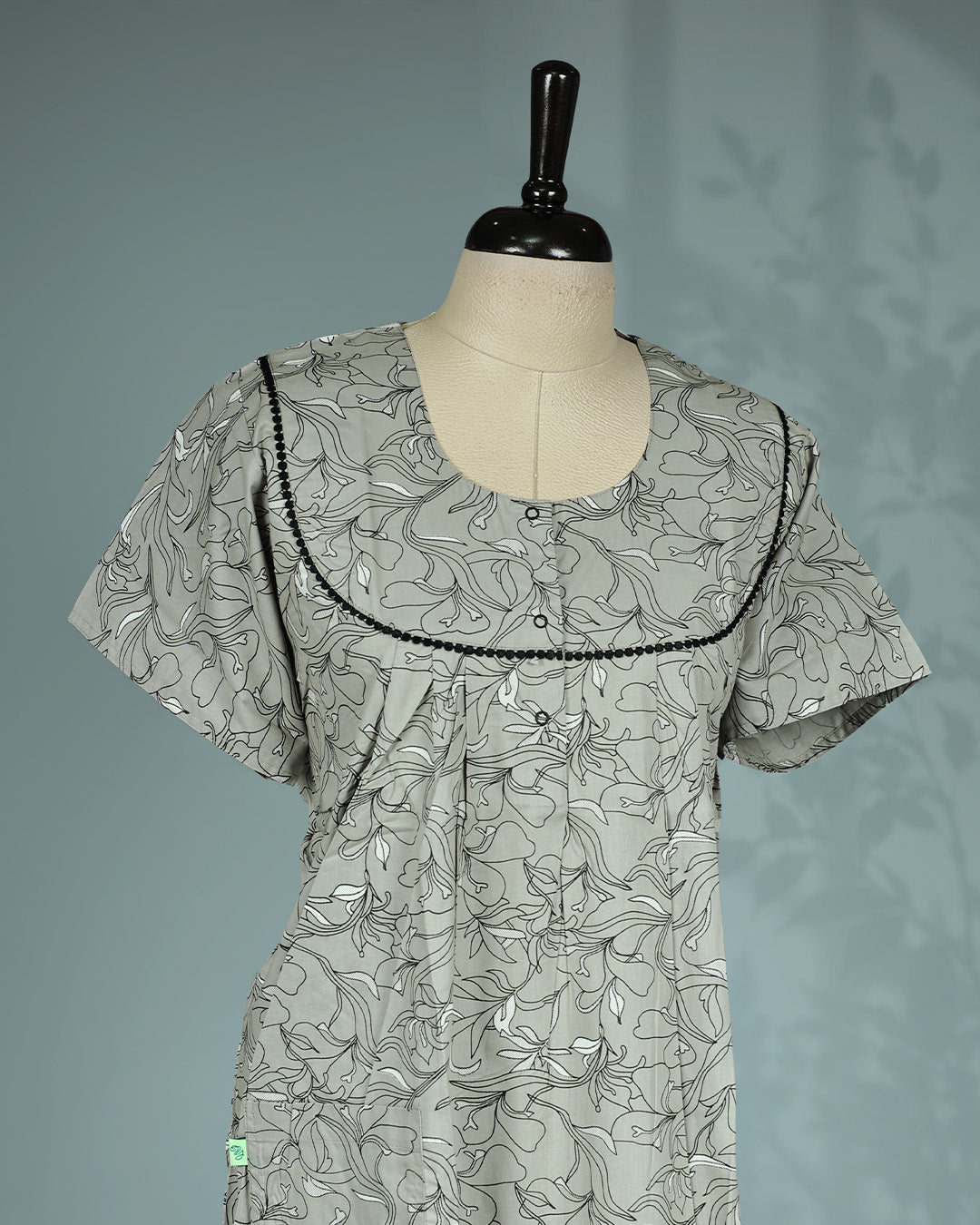 Light Grey colour nighty featuring floral prints on body, an openable button-front round neckline with black lace trim, short sleeves and an ankle-length fit.