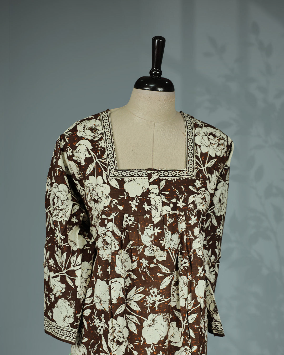 Olive Brown colour nighty featuring cream floral prints on body , an openable button-front square neckline with a printed border, three-quarter sleeves, front gathers and an ankle-length fit.