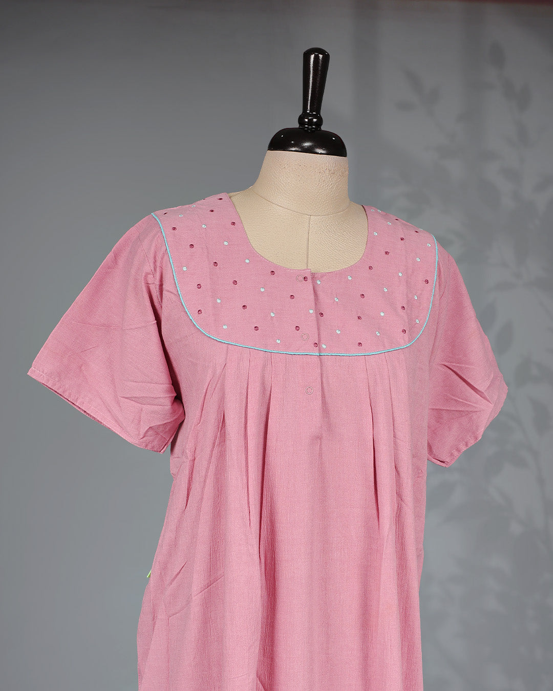 Baby Pink colour nighty featuring a Thread work on yoke, an U shaped openable button-front design, short sleeve and an ankle-length fit.