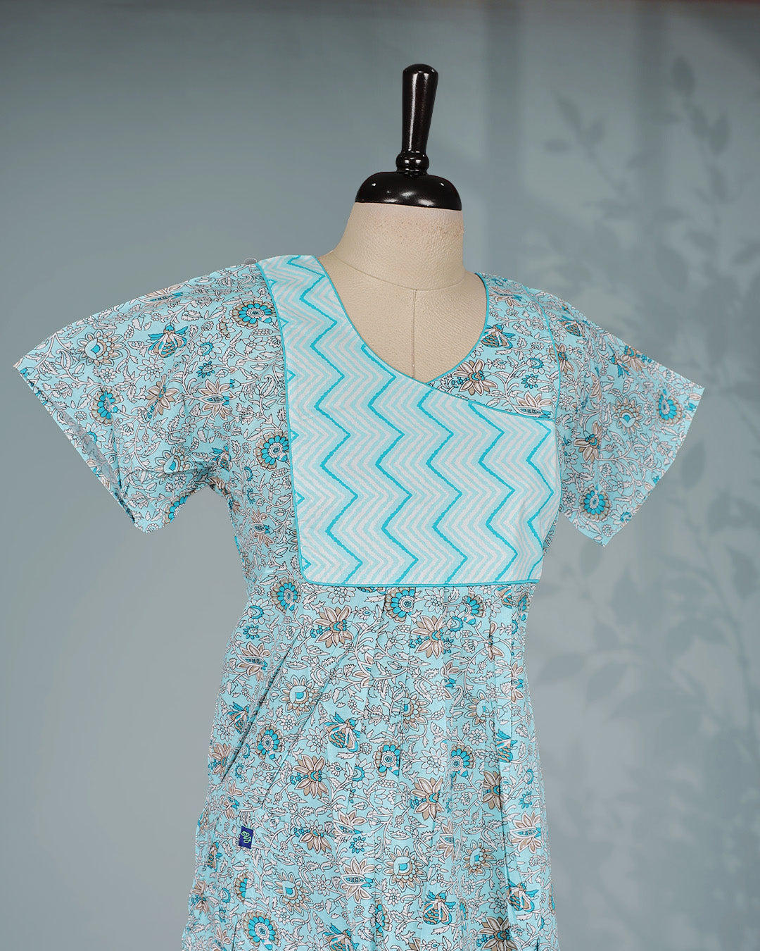 Sky blue floral kodi printed nighty with a stylish contrast asymmetrical yoke, V-neckline, short sleeves and ankle-length fit .