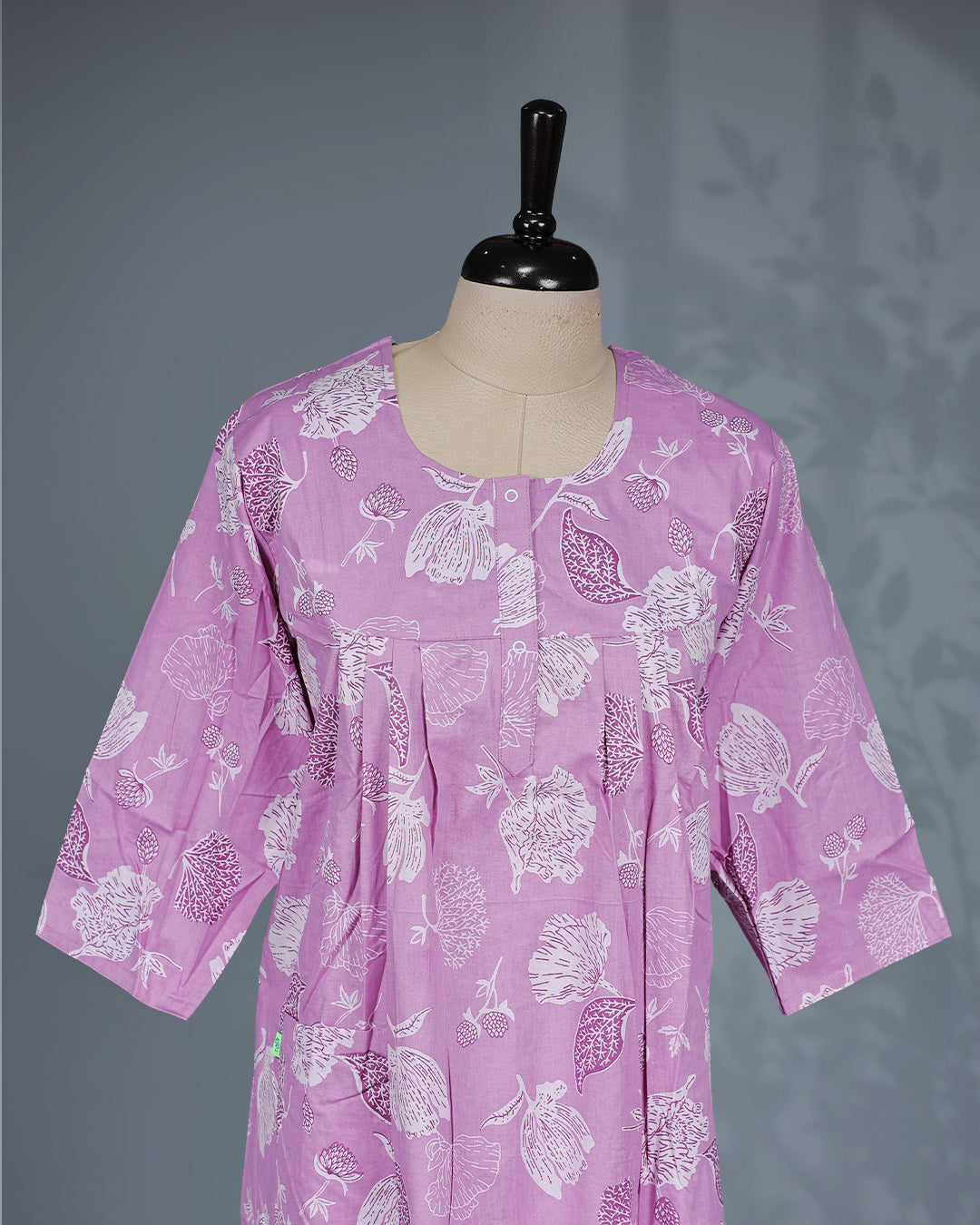 Light Purple colour nighty featuring white floral prints on body , an openable button-front round neckline, three-quarter sleeves and an ankle-length fit.
