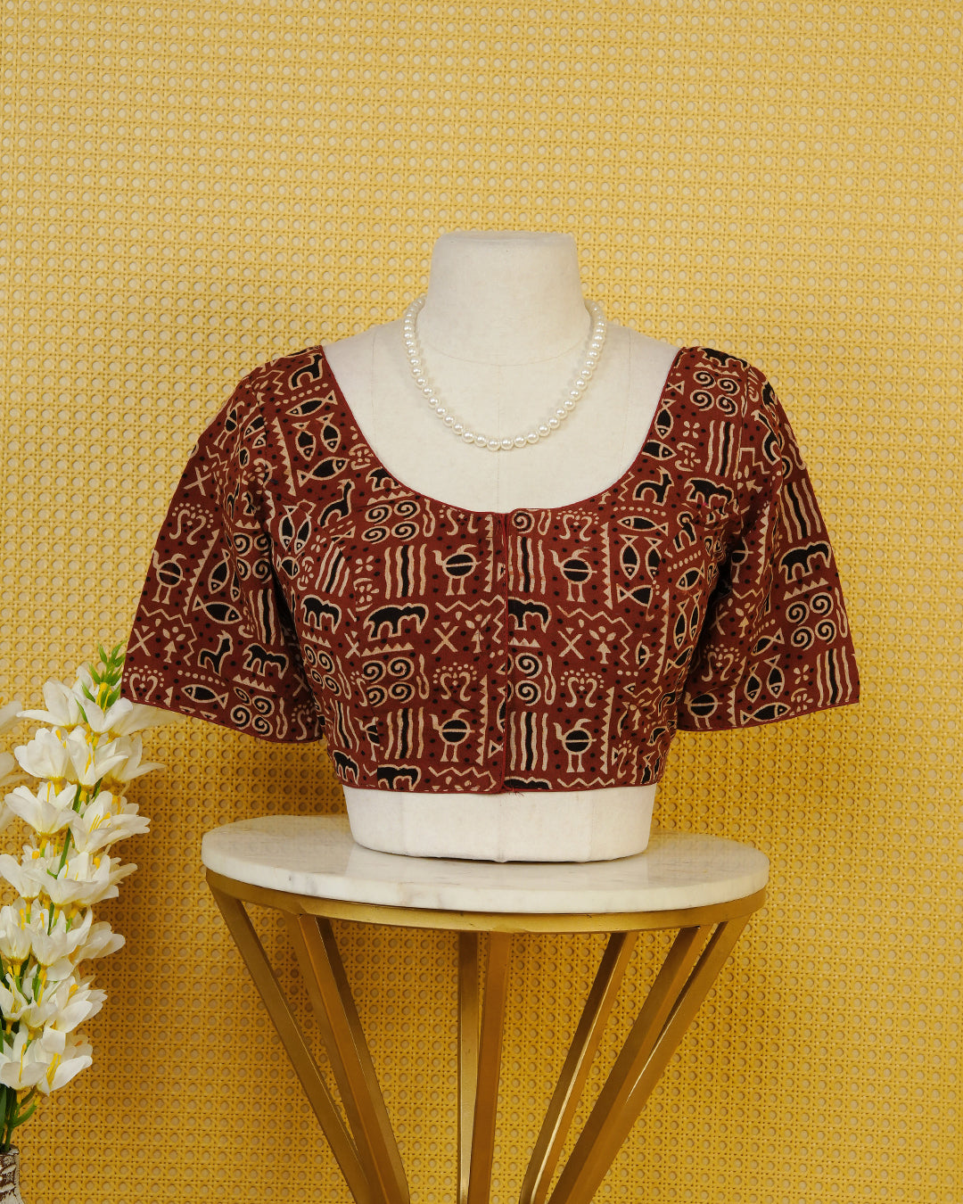 Maroon Colour Printed Blouse Featuring An All Over Tribal Inspired Geometric Motif Pattern, Enhanced With A Round Neckline, Front Button Closure, And Short Sleeves.