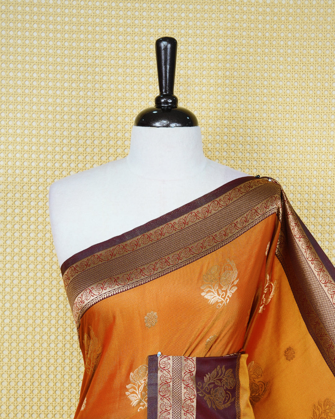 Rust orange colour Mulberry silk saree featuring gold floral zari patterns on body, paired with contrast maroon colour with traditional border, comes with matching blouse piece.