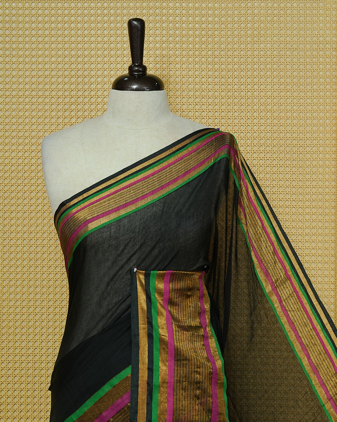 Black Mul Cotton Saree featuring a plain black body with a multicolour striped zari border in magenta, green, and gold, finished with dual-tone magenta and green tassels.