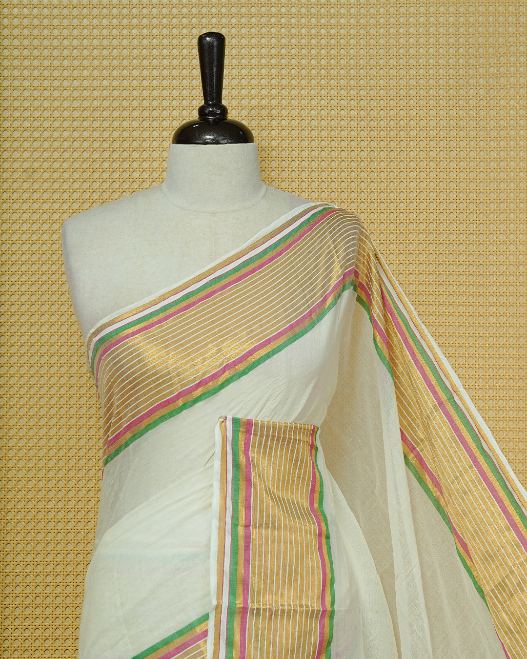 Off White Mul Cotton Saree featuring a gold zari striped border with pink and green accents, paired with a pallu and finished with green tassels.