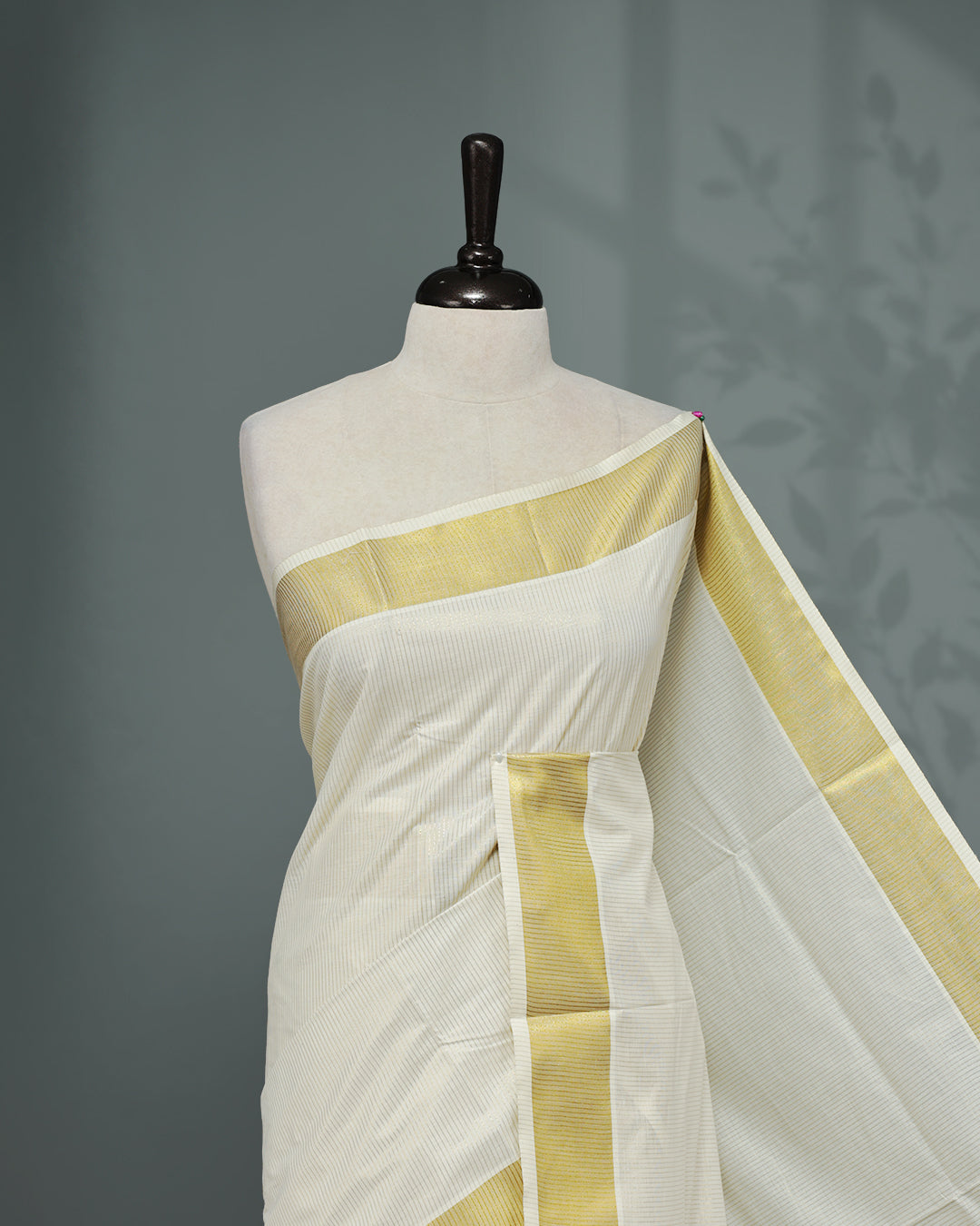 Cream colour Kerala saree Featuring Gold zari stripes on the body, complemented by a classic gold zari border, matching blouse piece.