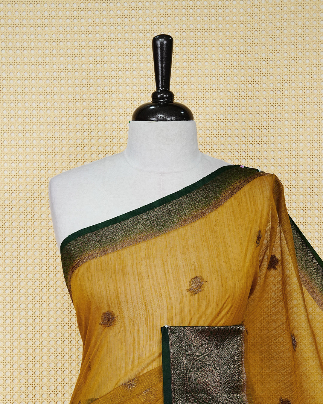 Mustard yellow colour semi linen saree thread motifs on body, contrast bottle green colour gold zari border, rich pallu comes with matching blouse piece