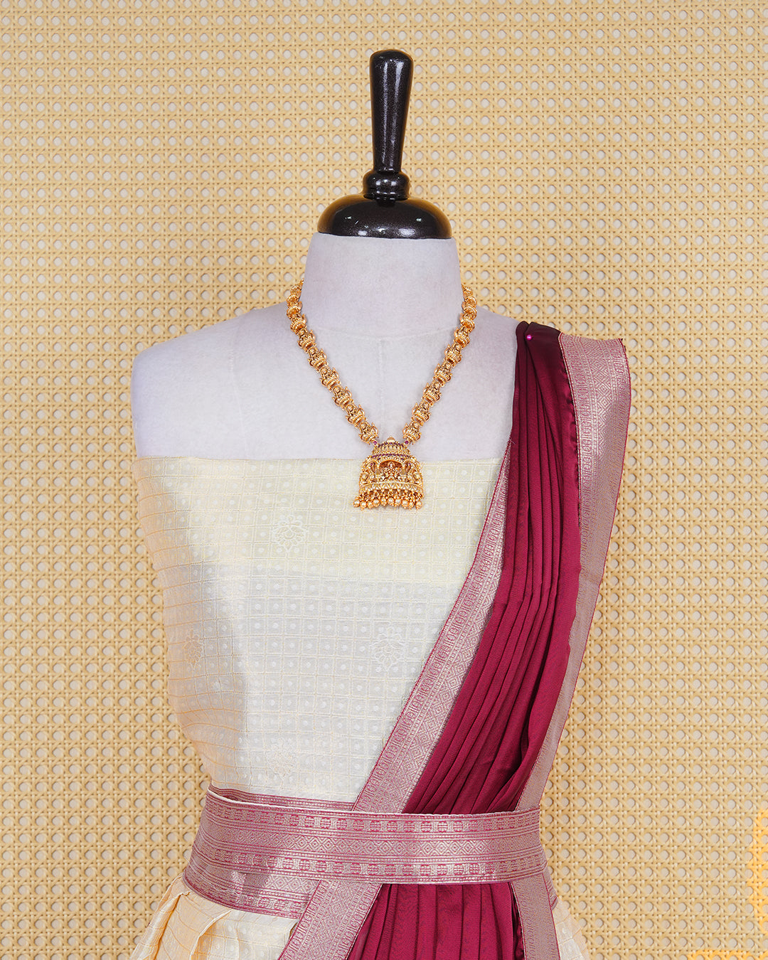 Cream colour tissue Semi stitched dhavani set featuring Gold zari check pattern with motifs on body ,contrast Brick Red colour with gold zari bordered skirt, paired with matching blouse piece & dupatta.