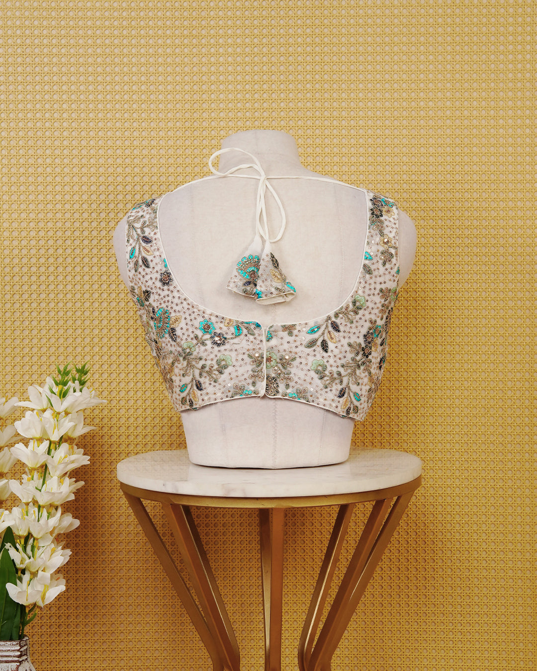 Ivory colour Embroidered Sleeveless Blouse Featuring A Stylish V-Neck, Intricate Floral Embroidery With Sequin Detailing, And A Comfortable Tailored Fit.