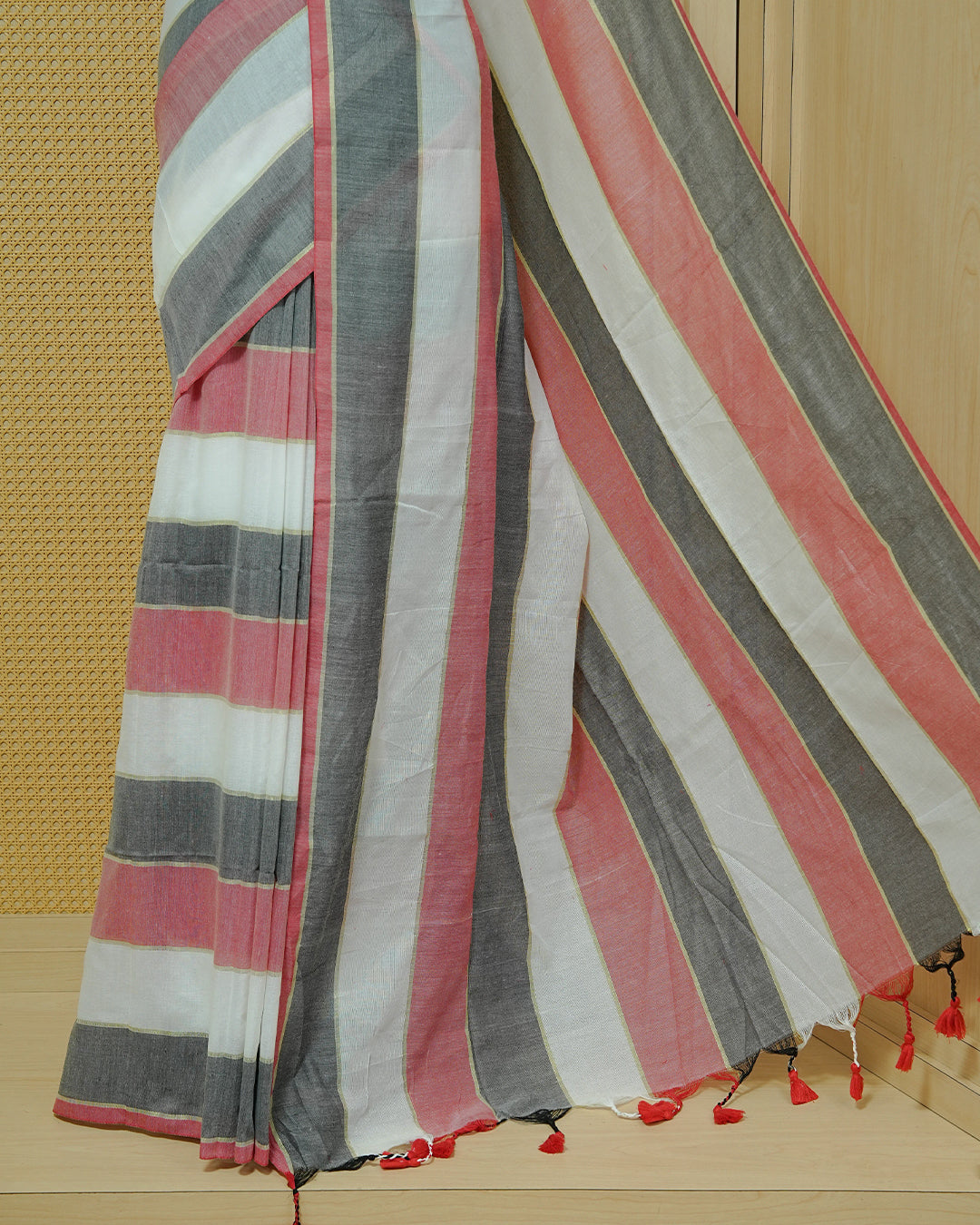 Off White,Charcoal Grey & Red Striped Mul Cotton Saree featuring bold striped patterns in white, charcoal grey, and Red, finished with delicate red tassels.