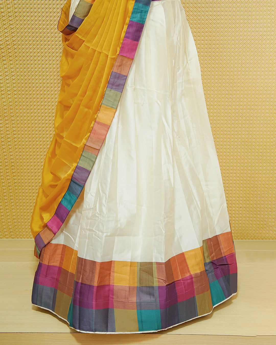 Cream colour Semi stitched Dhavani set Featuring Cream elegant plain with Mutlicolour bos patterned border skirt, comes with matching blouse piece & dupatta.