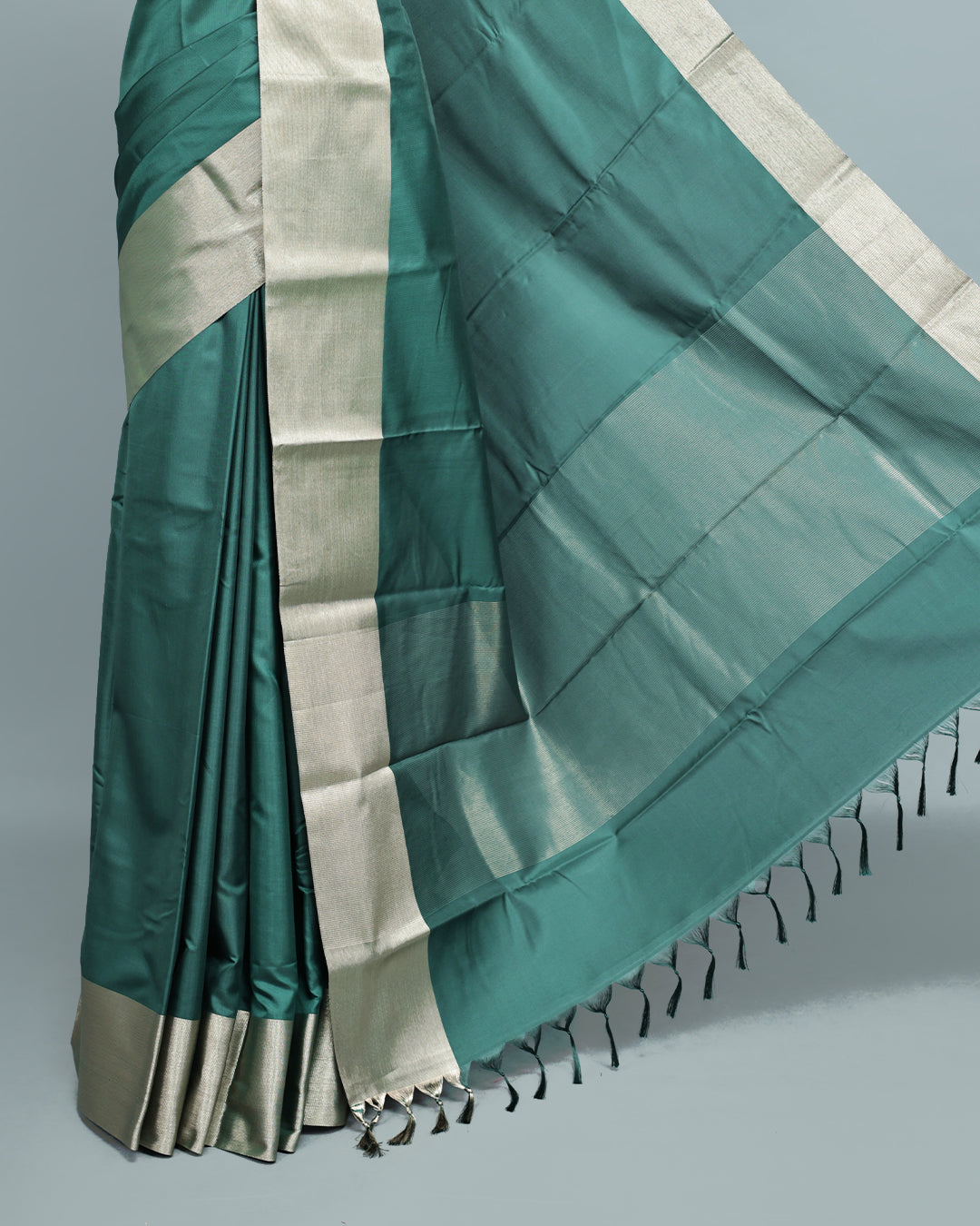 Green colour saree featuring a plain body, complemented by a Bavanchi border and contrast pallu, paired with a matching blouse piece.