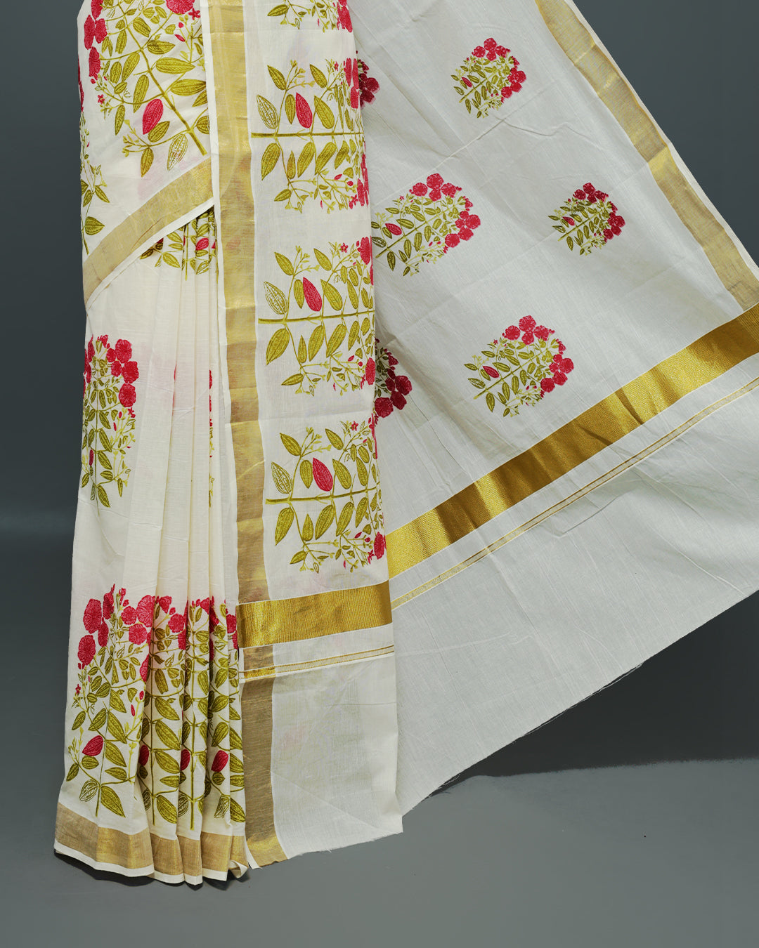Cream colour Cotton kerala saree featuring Magenta colour floral Print on the body, complemented by a gold zari Border, paired with a matching blouse piece.