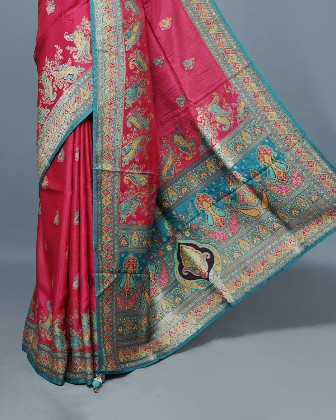 Rani Pink Colour Pashmina Saree featuring Mango motifs on body, complemented by Contrast Teal colour with Floral pattern & gold zari on border and Pallu, comes with matching blouse piece.