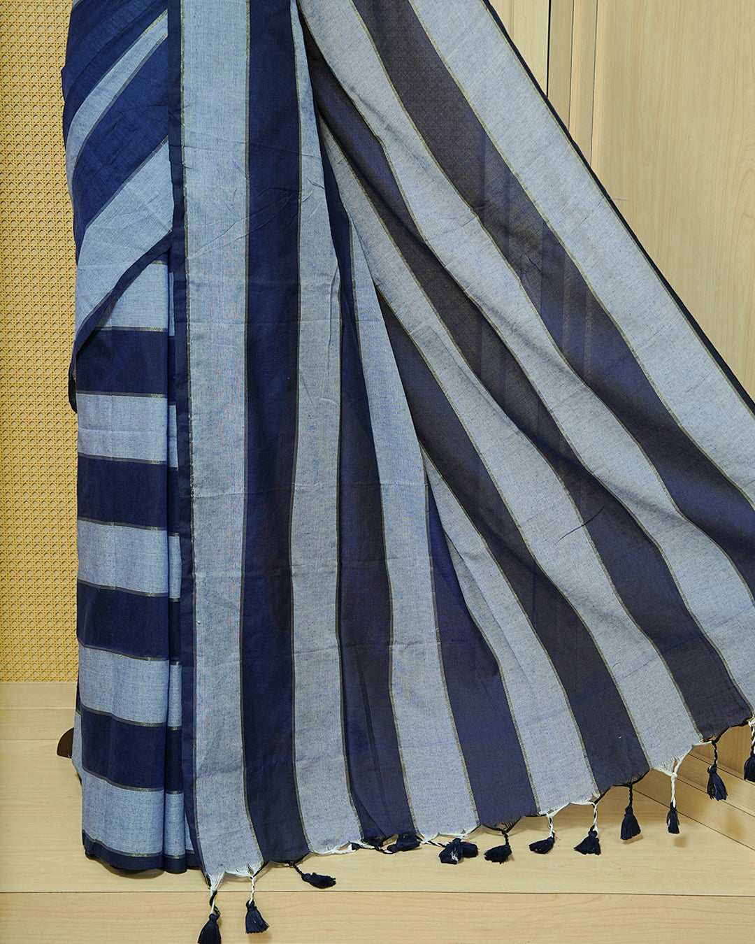 Navy Blue & Light Blue colour Mul cotton saree featuring Gold zari strips, complemented by self colour simple Border & tassels.