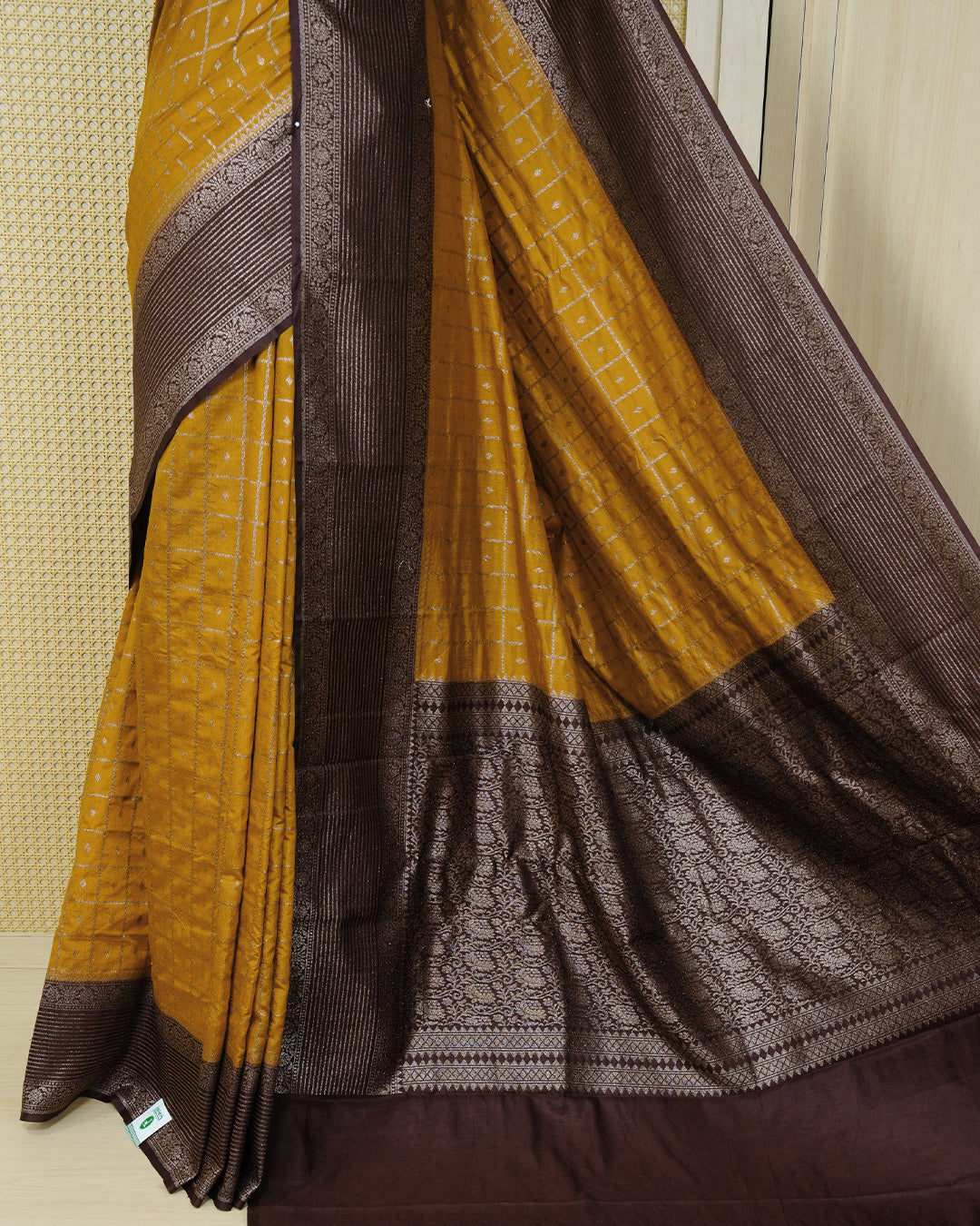 Mustard yellow Colour Semi georgette Saree having zari check with buttas pattern on body, contrast dark chocolate colour floral designed border, Rich Pallu comes with Matching Blouse piece.