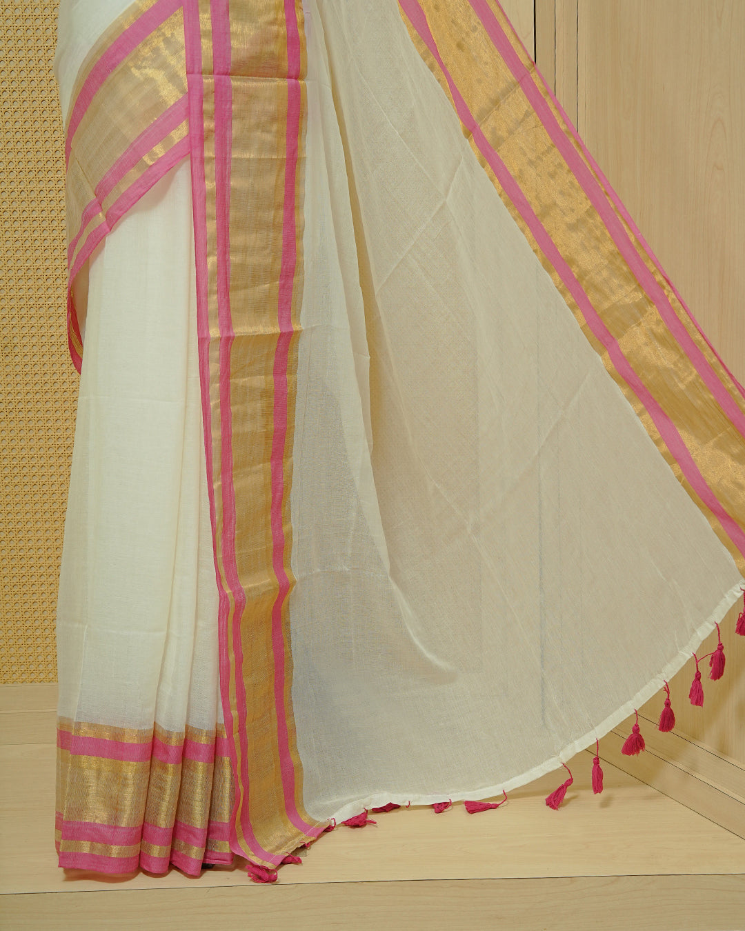 Off White Mul Cotton Saree featuring a gold zari border with pink stripes, A Matching Pallu & finished with pink tassels