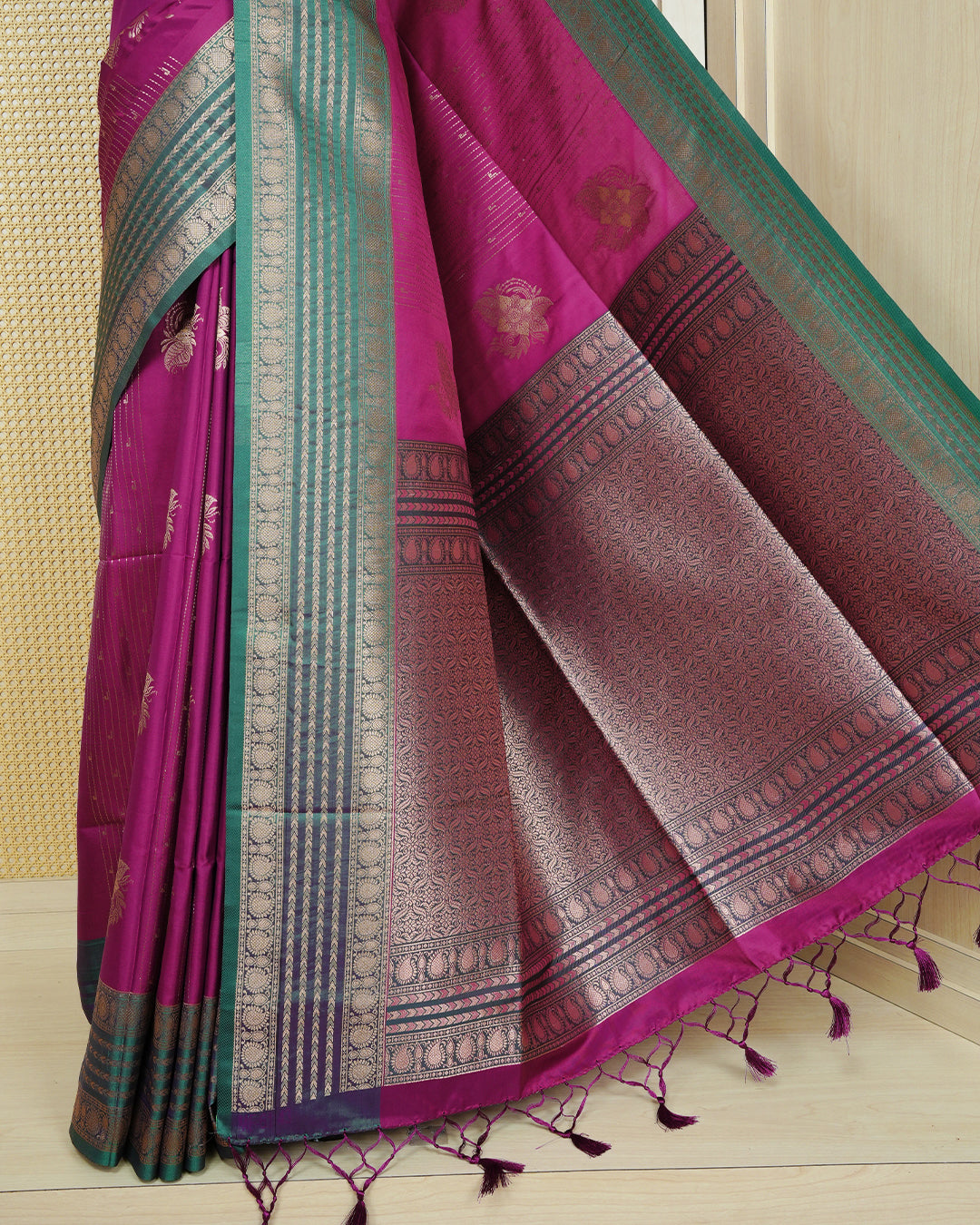 Purple colour Mulberry silk saree featuring gold floral zari patterns on body, paired with contrast green colour with traditional border, comes with matching blouse piece.