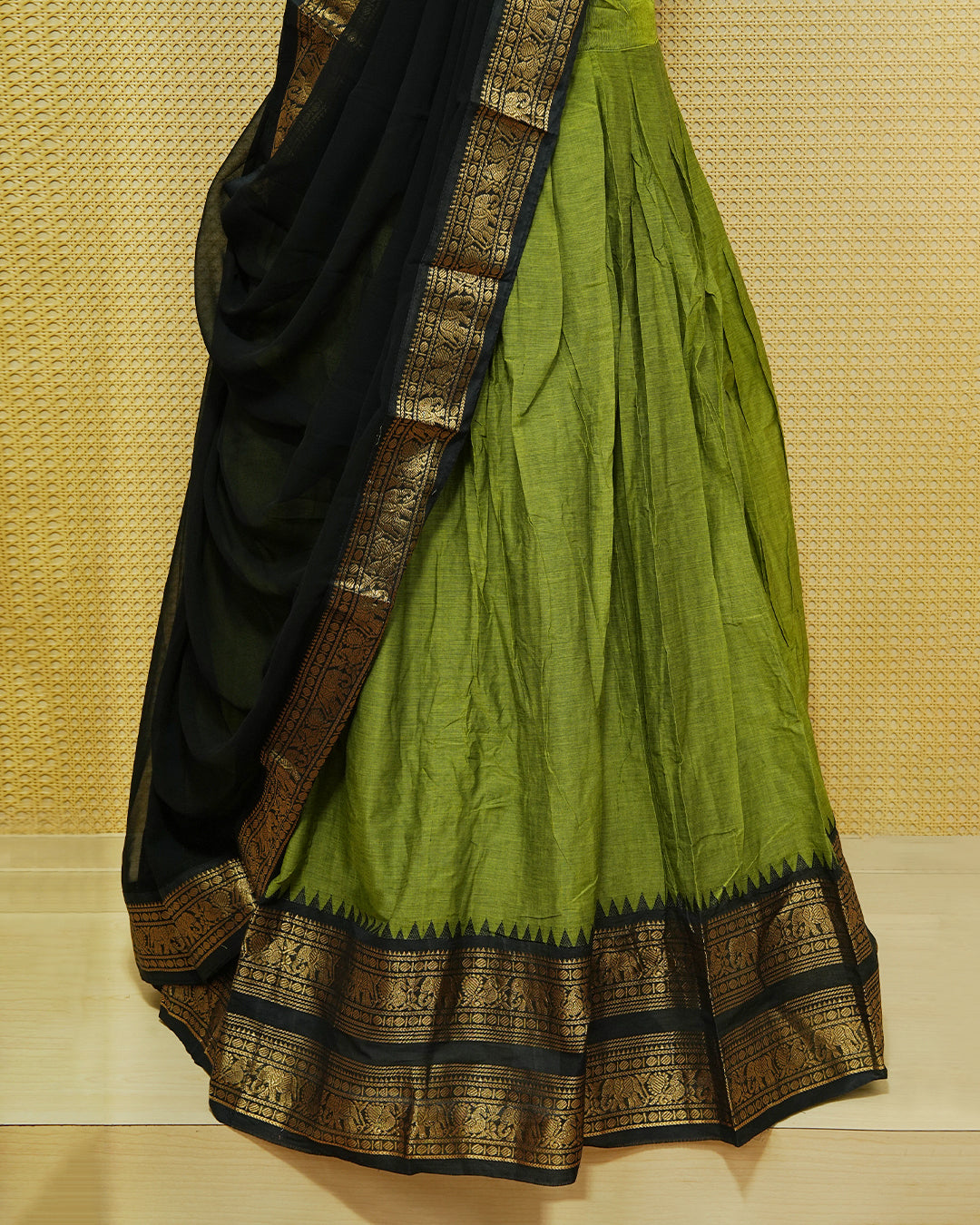 Green colour Chettinad Semi Stitched dhavani set Featuring contrast Black with Gold zari border on skirt, Contrast Blouse & matching dupatta.