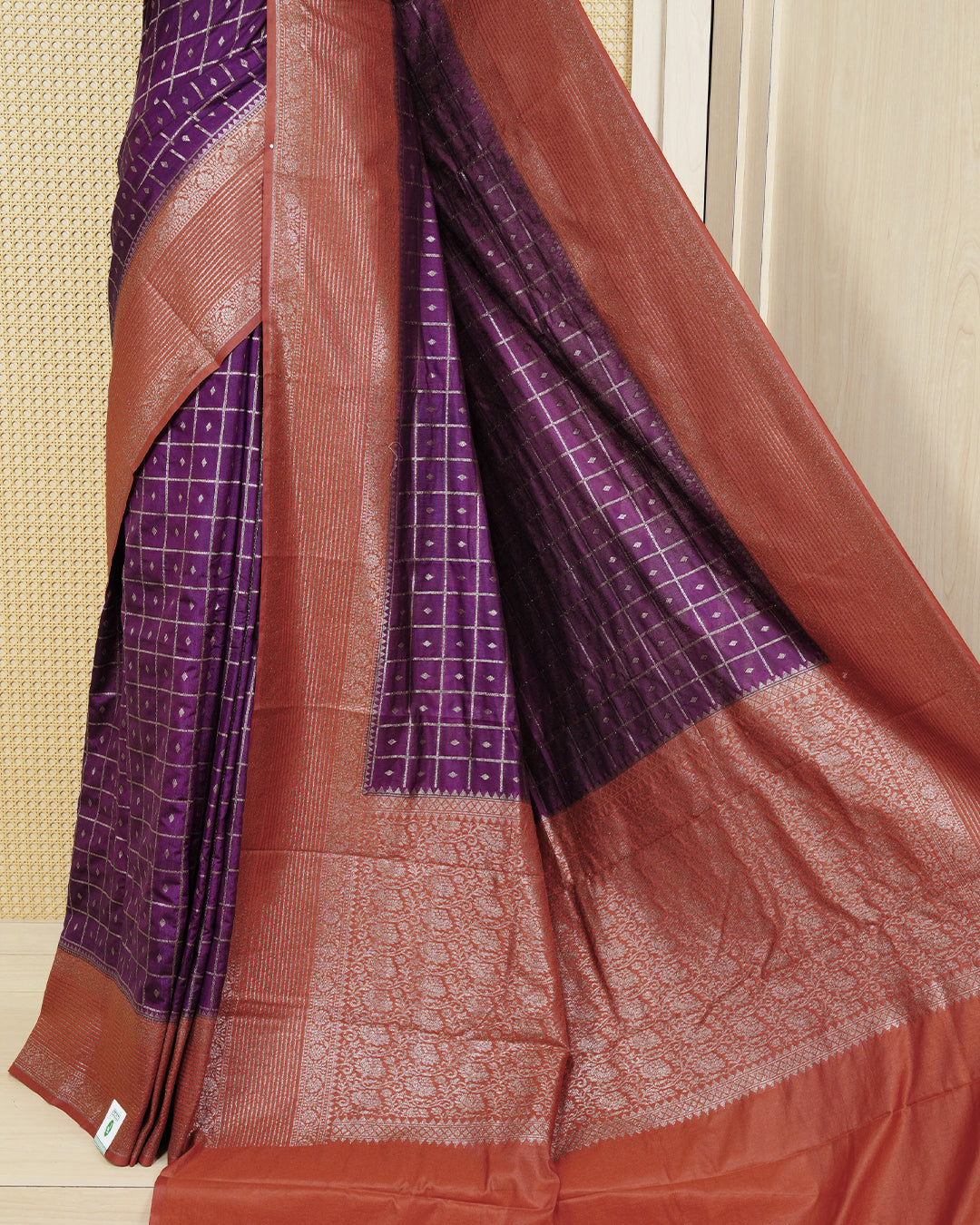 Grape Colour Semi georgette Saree having zari check with buttas pattern on body, contrast rust orange colour floral designed border, Rich Pallu comes with Matching Blouse piece.