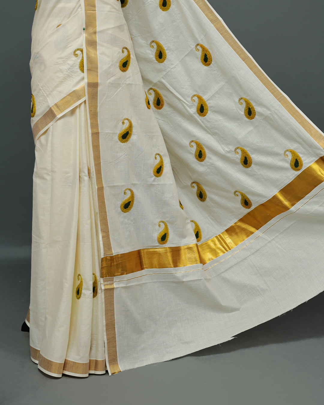 Cream colour Cotton kerala saree featuring Mango Embroidery work on the body, complemented by a gold zari Border, paired with a matching blouse piece.