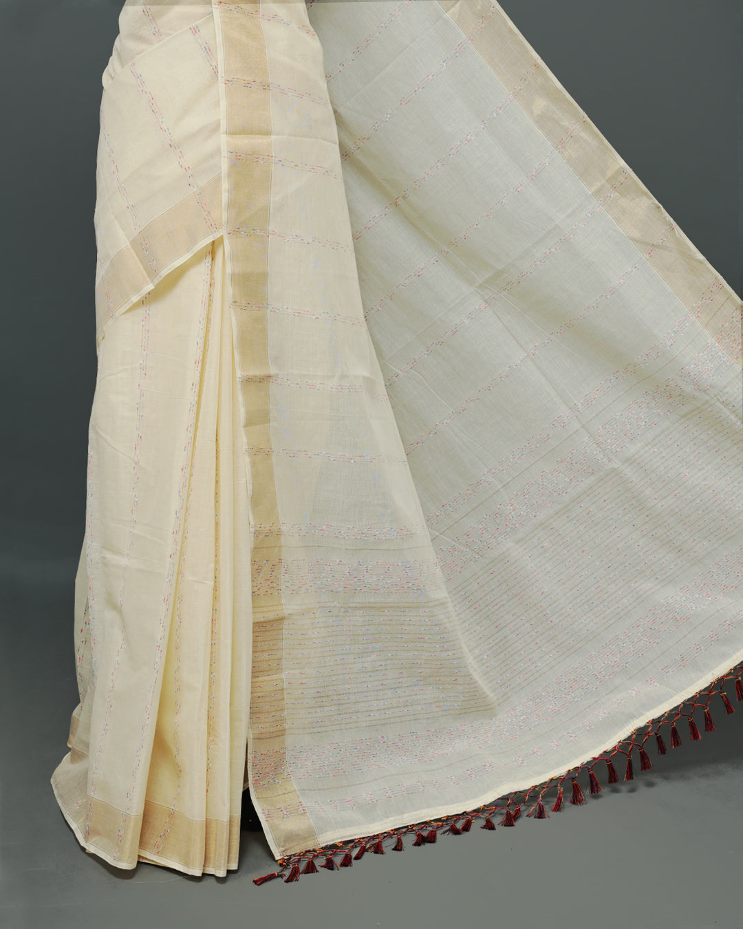 Cream colour Cotton kerala saree featuring Multicolour & gold Strips on body, complemented by Gold zari Border, paired with matching blouse piece.