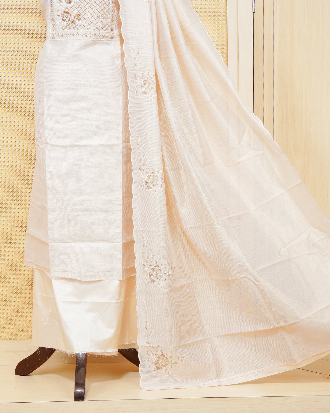 Cream colour tissue salwar material featuring an elegant floral pattern on body, beadwork on chest portion, paired with a matching bottom and an elegant dupatta.