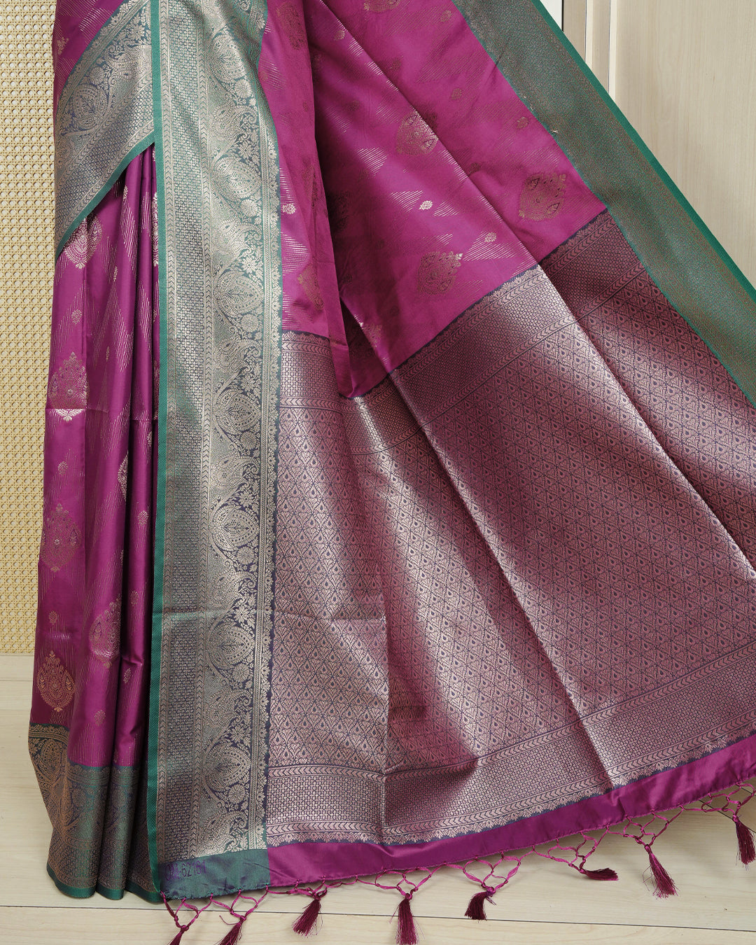 Magenta colour Mulberry silk saree featuring gold floral zari patterns on body, paired with contrast green colour with traditional border, comes with matching blouse piece.
