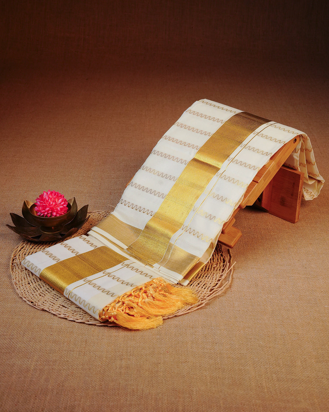 Cream colour cotton set mundu Featuring Gold zari zigzag Strips on body, complemented by classy golden kara.