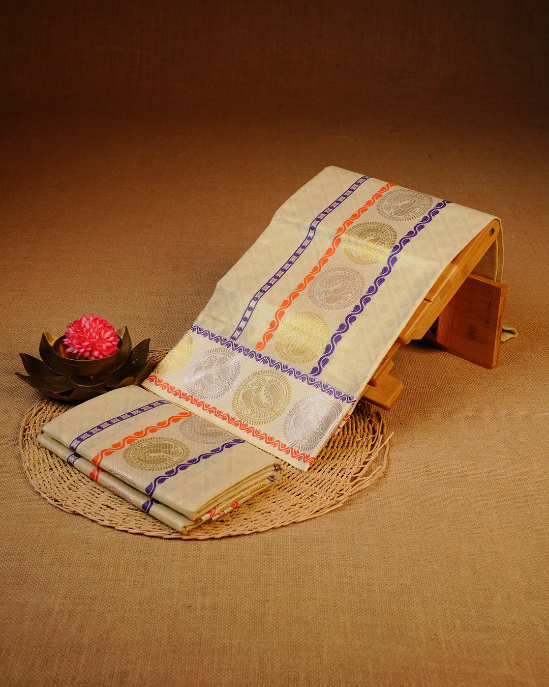 Golden colour Tissue silk set mundu features a plain body accented by a Blue, Orange with Gold & Rosegold Chakra Motifs on border.