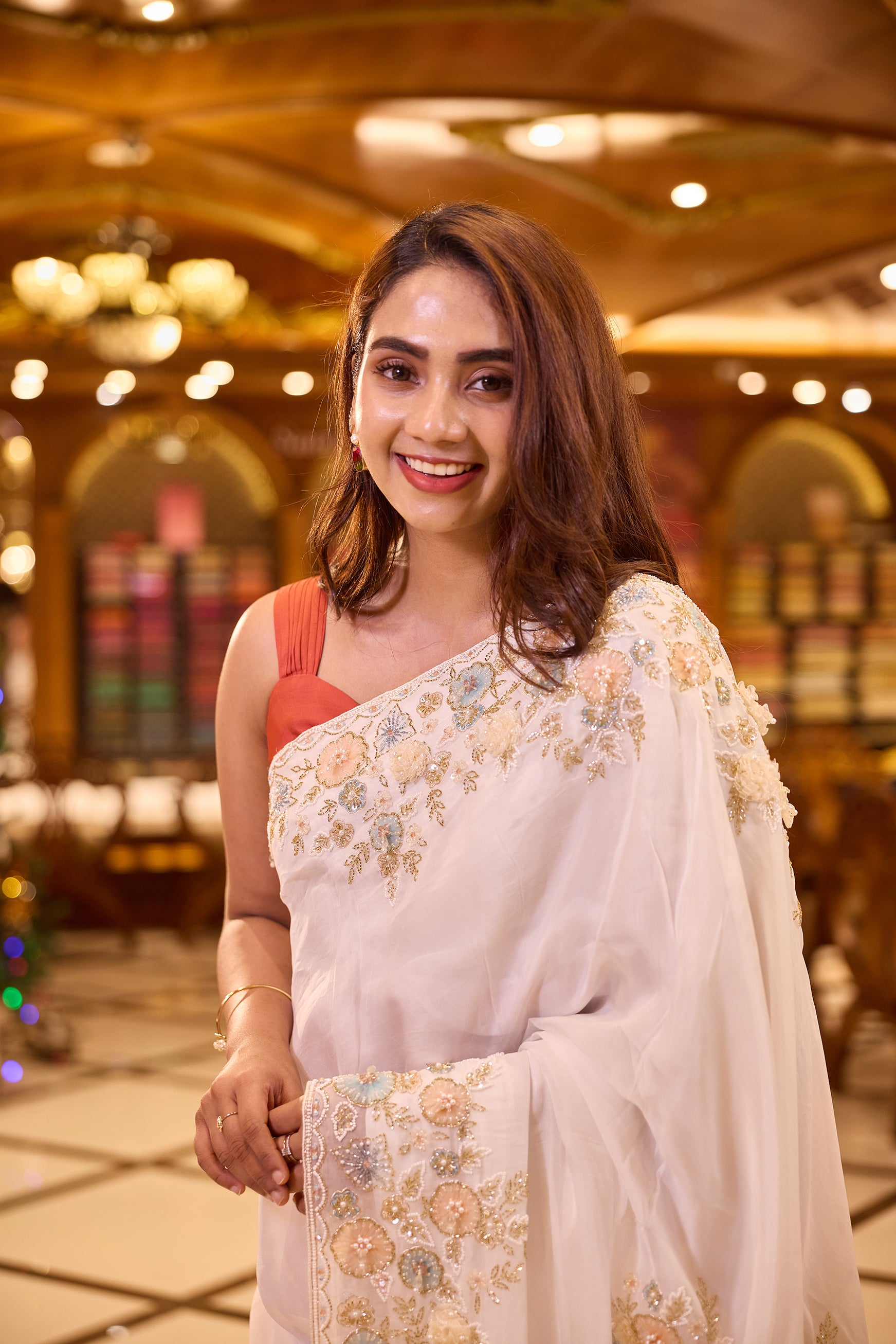 White colour Pure Organza designer saree adorned with pastel floral bead, pearl and sequin embroidery, finished with a richly embellished border, paired beautifully with a matching designer blouse