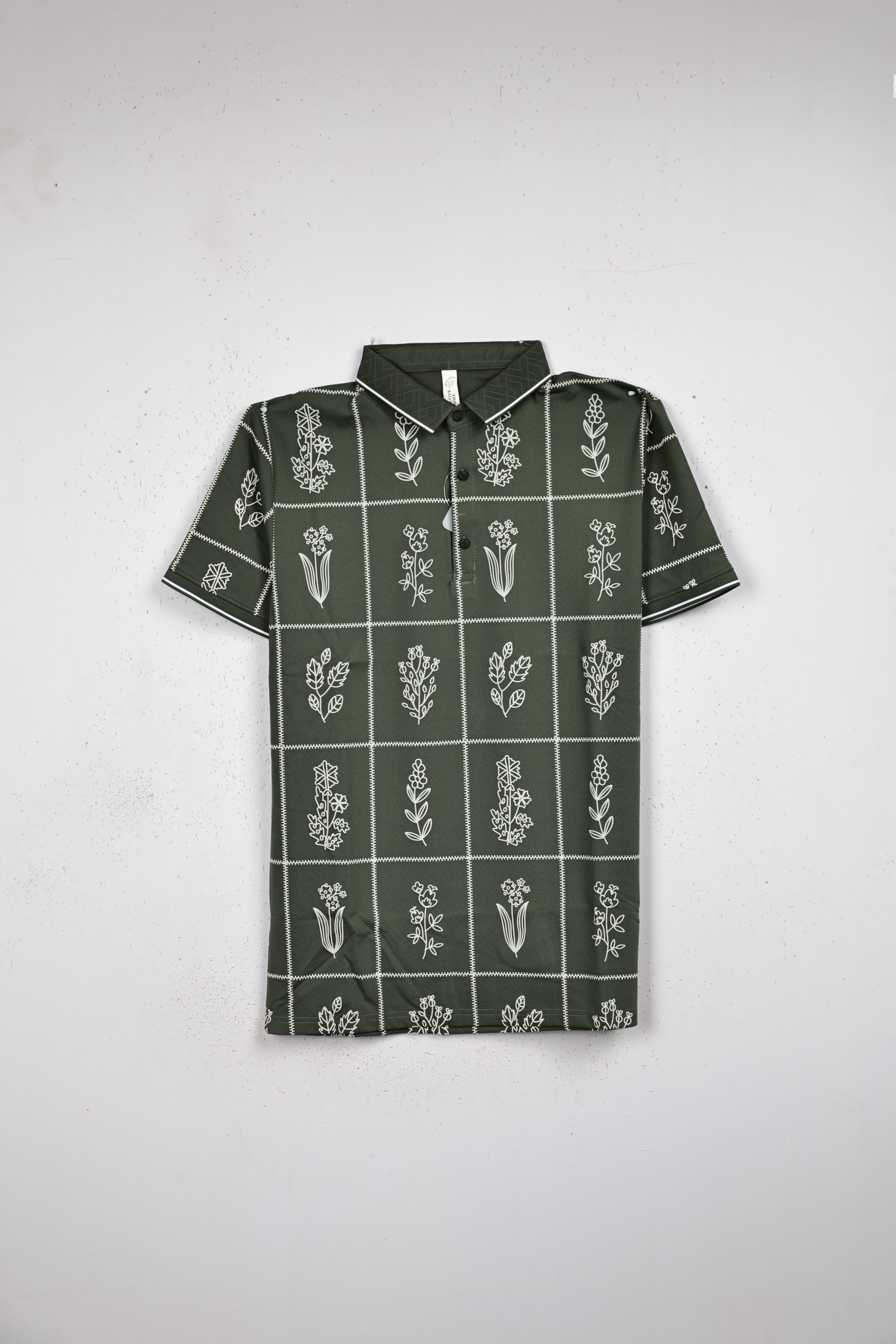 Green colour T shirt featuring white pattern on body, collar design neck, Half sleeve.