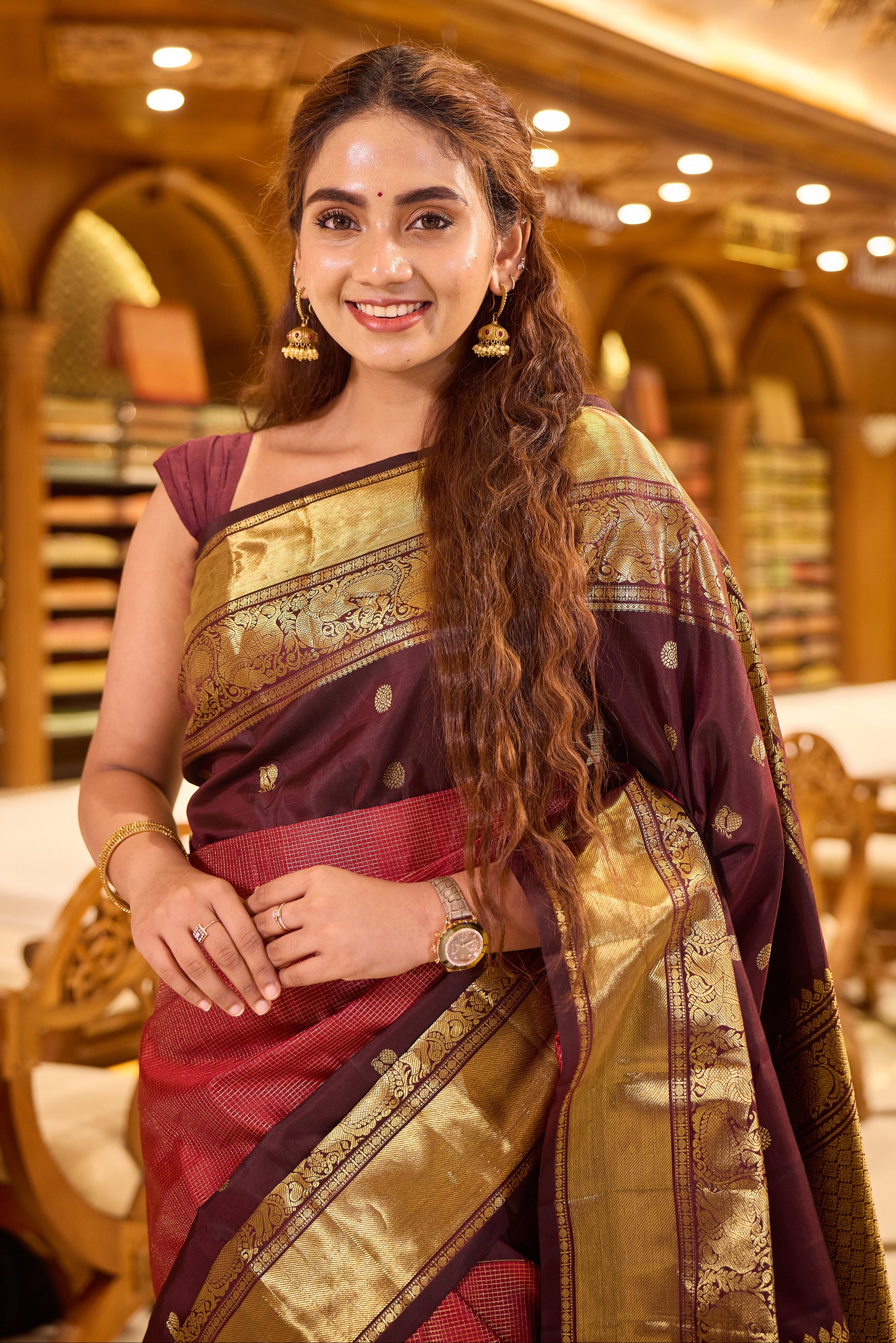 Maroon & Brown Shade Kanchipuram Traditional Handloom Silk Saree featuring vaira oosi zari checks on the body with contrasting Mayuri chakra motifs woven in rich antique gold zari, elegantly finished with a classic gold zari border.