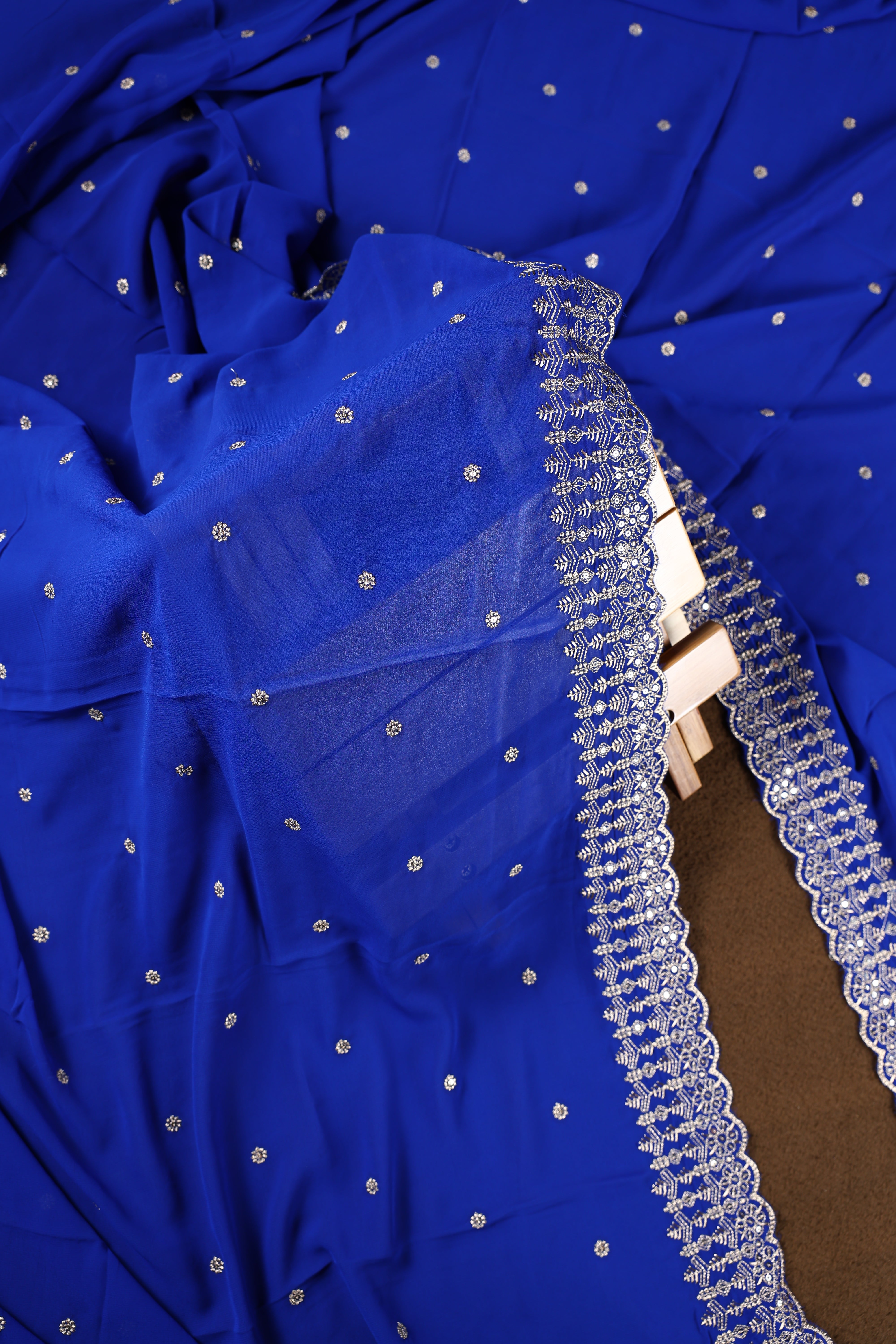 Royal blue colour churidhar material beautifully designed with golden floral embroidery and multicolour thread highlights, paired with a plain matching bottom and an elegant embroidered dupatta.