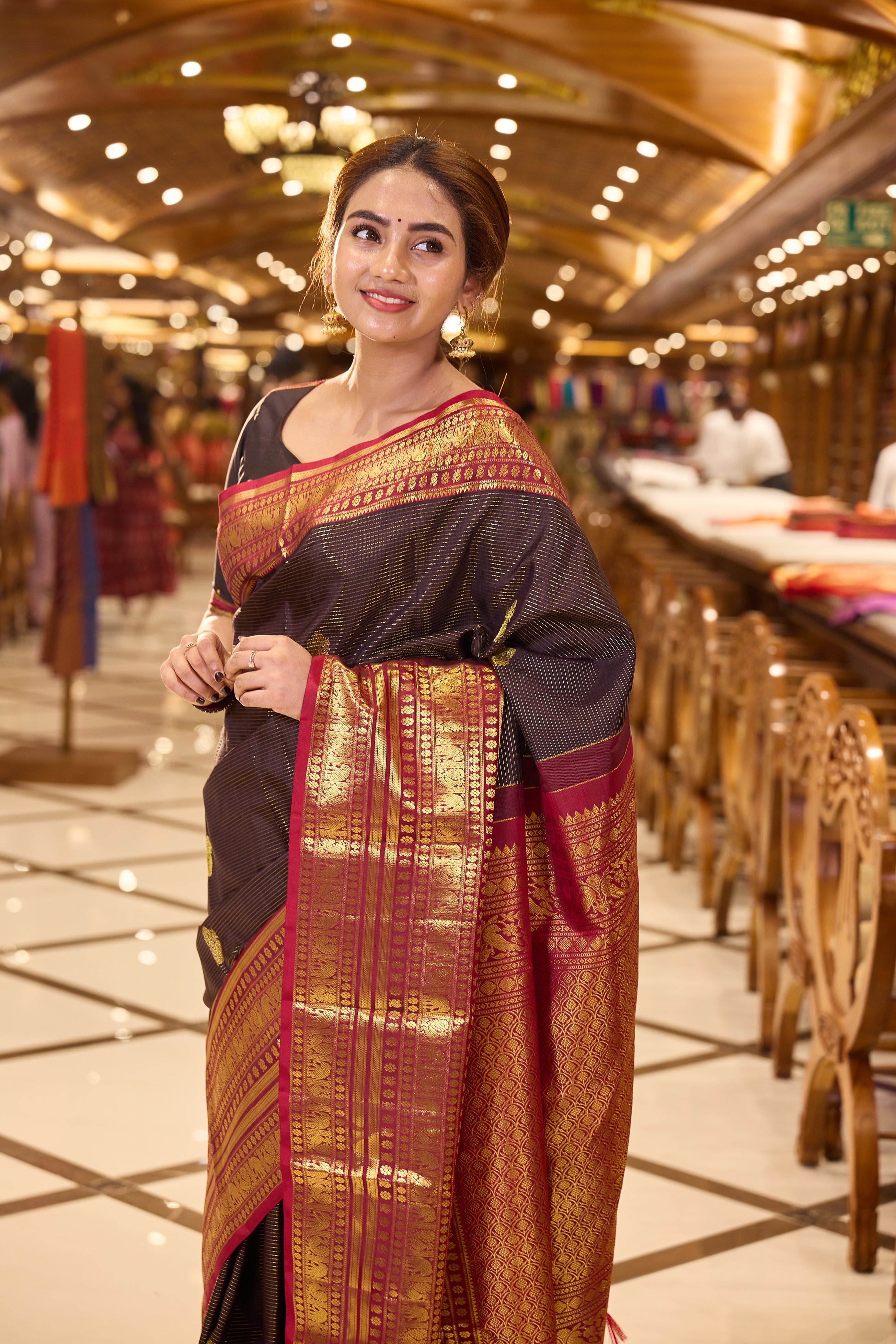 Dark Brown Kanchipuram Silk saree with traditional Vaira Oosi lines and peacock motif weaving, contrast Maroon and Gold Zari traditional long border and pallu, paired with matching blouse piece.