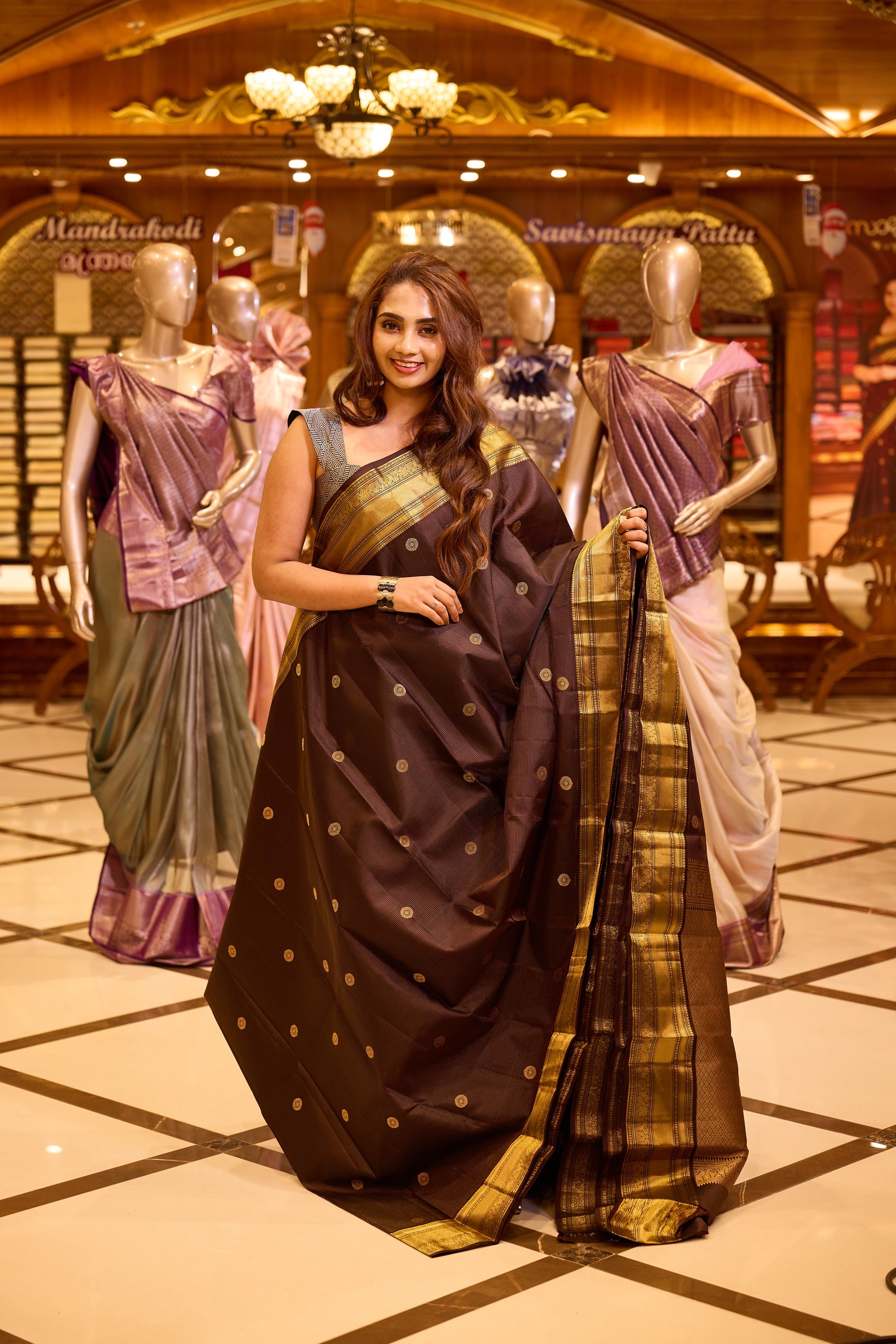 Graceful deep chocolate brown colour Kancheepuram silk saree adorned with delicate gold zari motifs across the body, beautifully finished with a broad traditional gold zari border, exuding timeless elegance and paired with a matching blouse piece