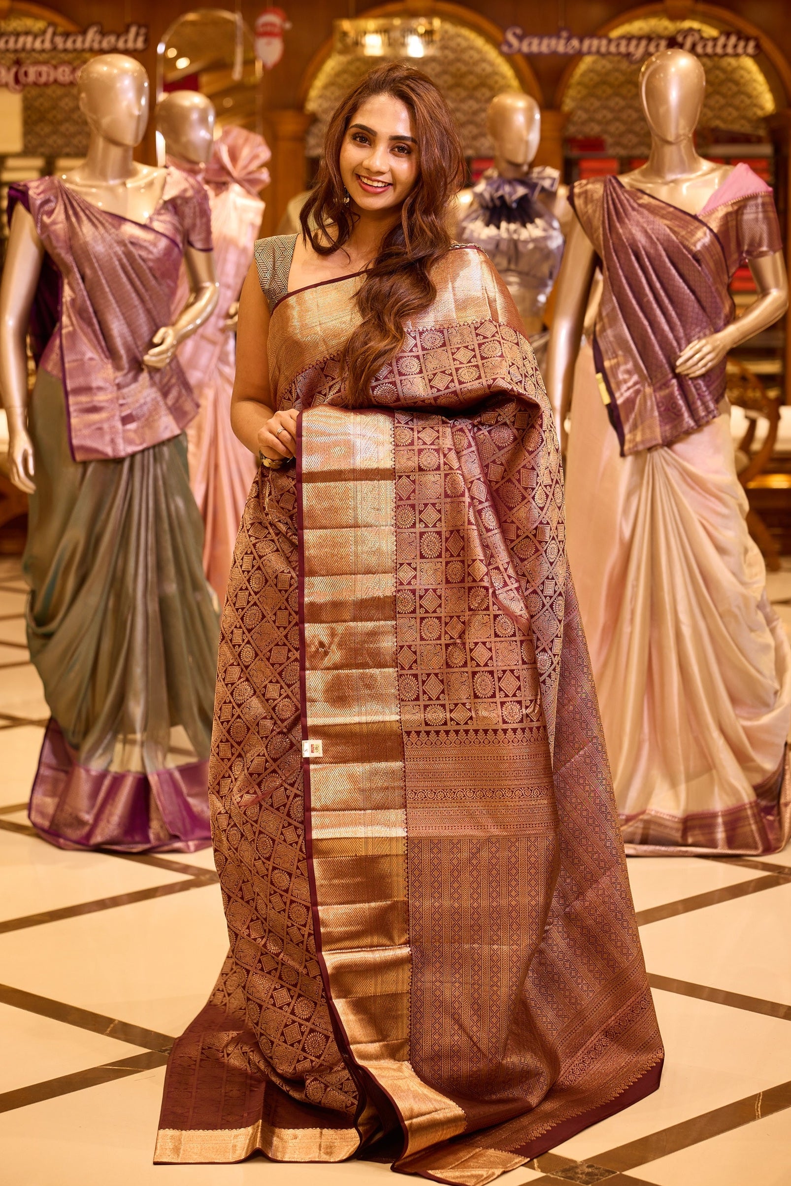 Elegant wine brown colour Kancheepuram silk saree adorned with an all over rich geometric zari weave, beautifully complemented by a broad traditional gold zari border and paired with a matching blouse piece