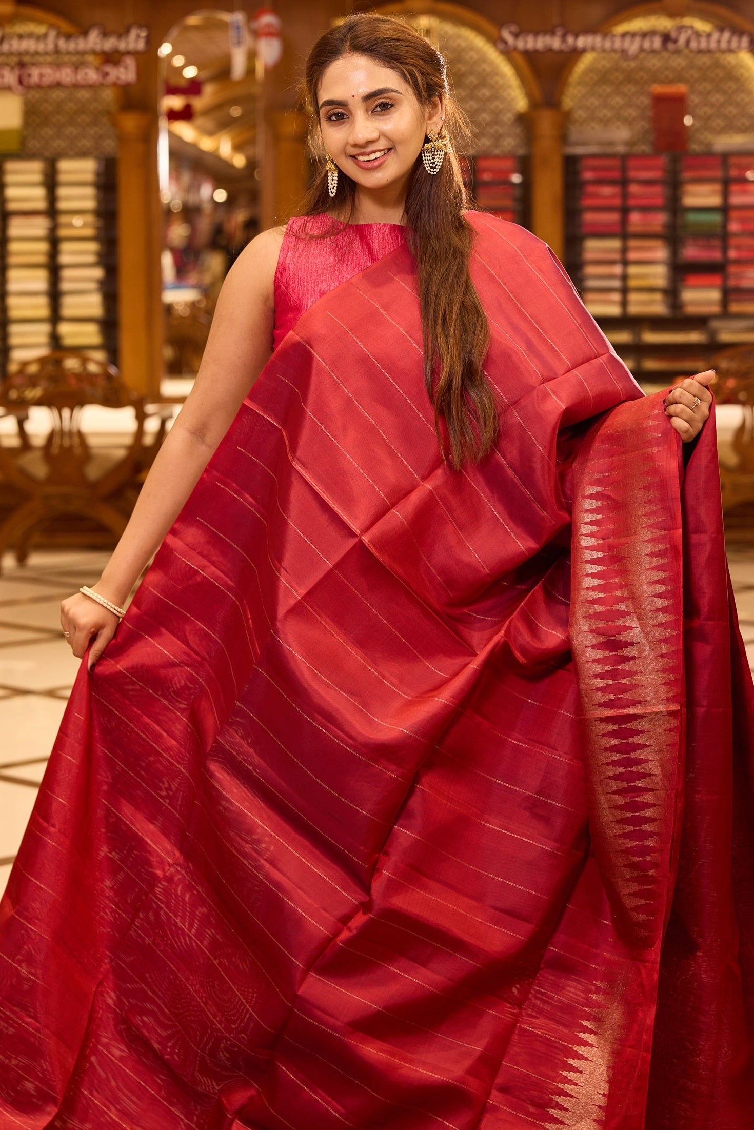 Brick red colour pure Mayuri Soft silk saree featuring a graceful striped body and a refined double temple border on one side, finished with a rich sheen and paired with a matching blouse