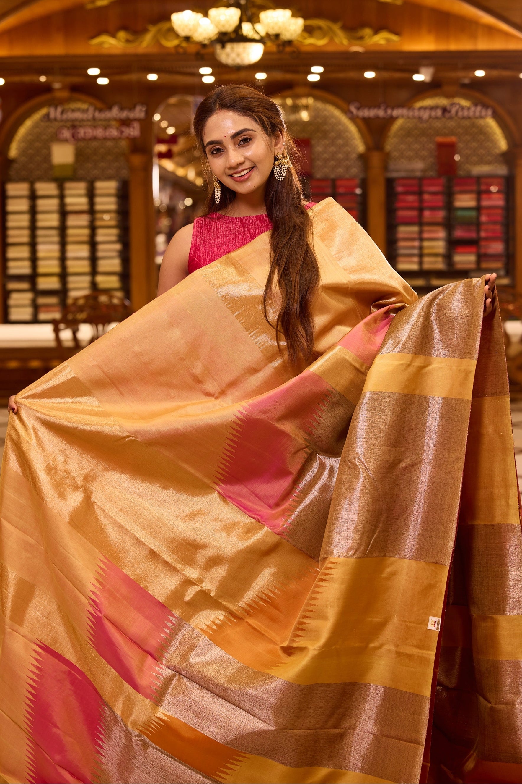 Elegant golden beige colour Kancheepuram silk saree featuring subtle woven geometric highlights with soft pink accents, beautifully paired with a rich contrast pallu and styled with a vibrant blouse