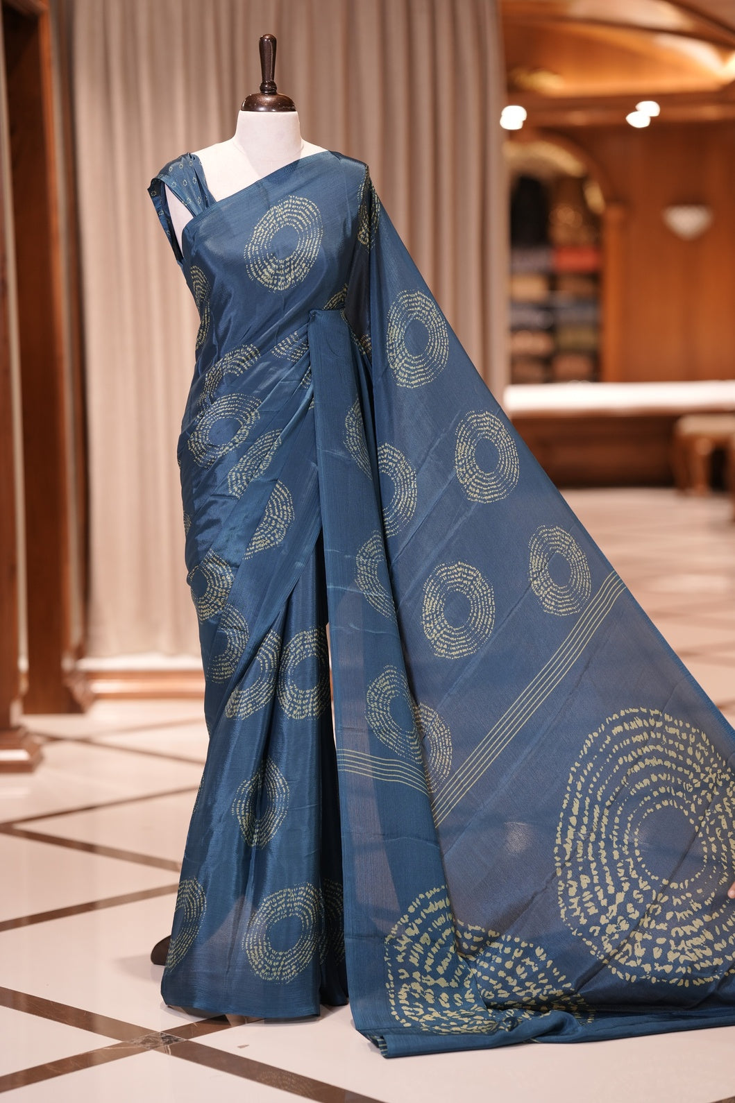 Teal Blue colour Turkey crepe saree featuring elegant circle designs all over, with a large circular pattern on the pallu and delicate small circle motifs on the matching blouse piece for a graceful look.