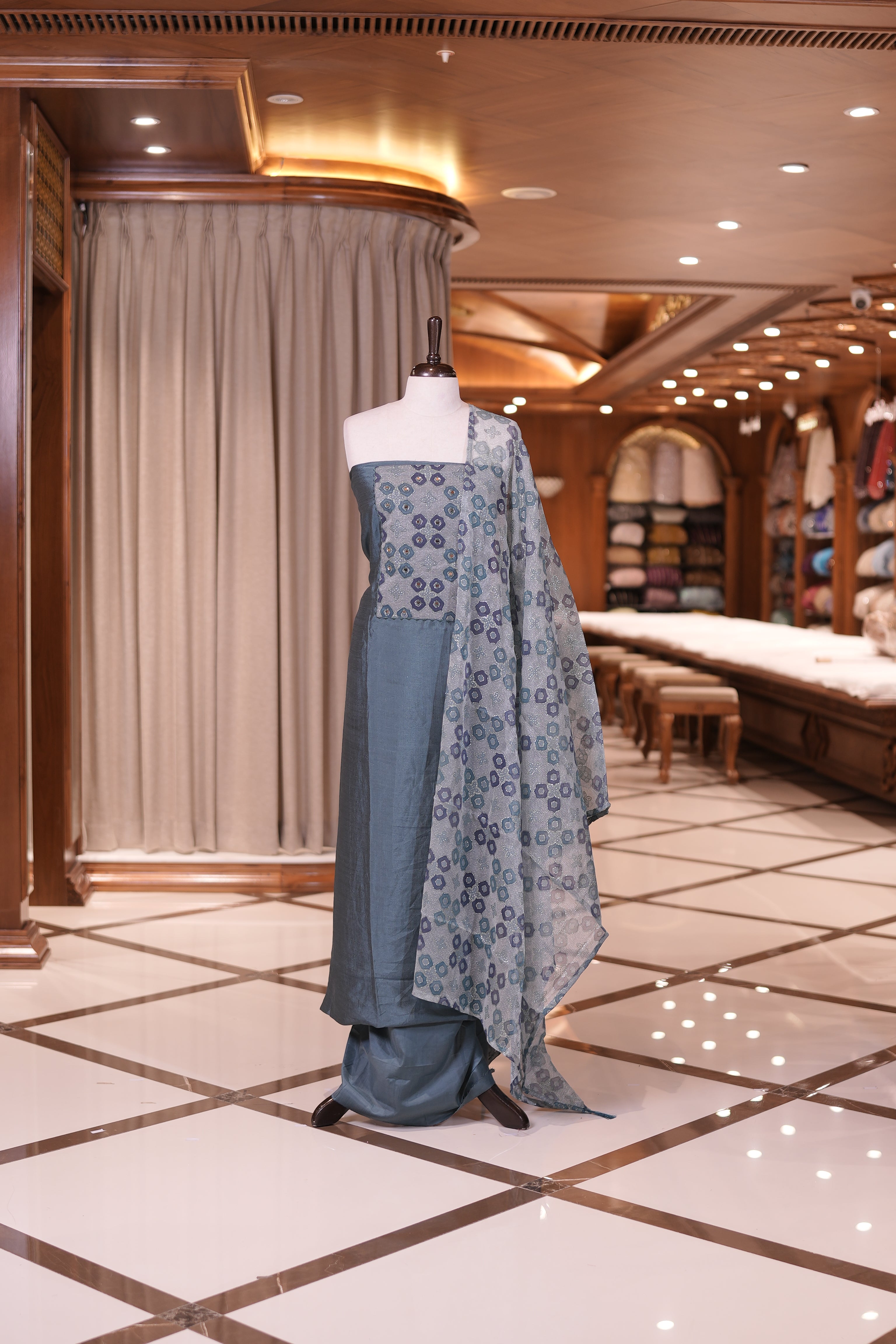 Teal Green colour silk top embellished with elegant geometric patterns and mirror work, paired with a matching designed dupatta and a plain bottom.