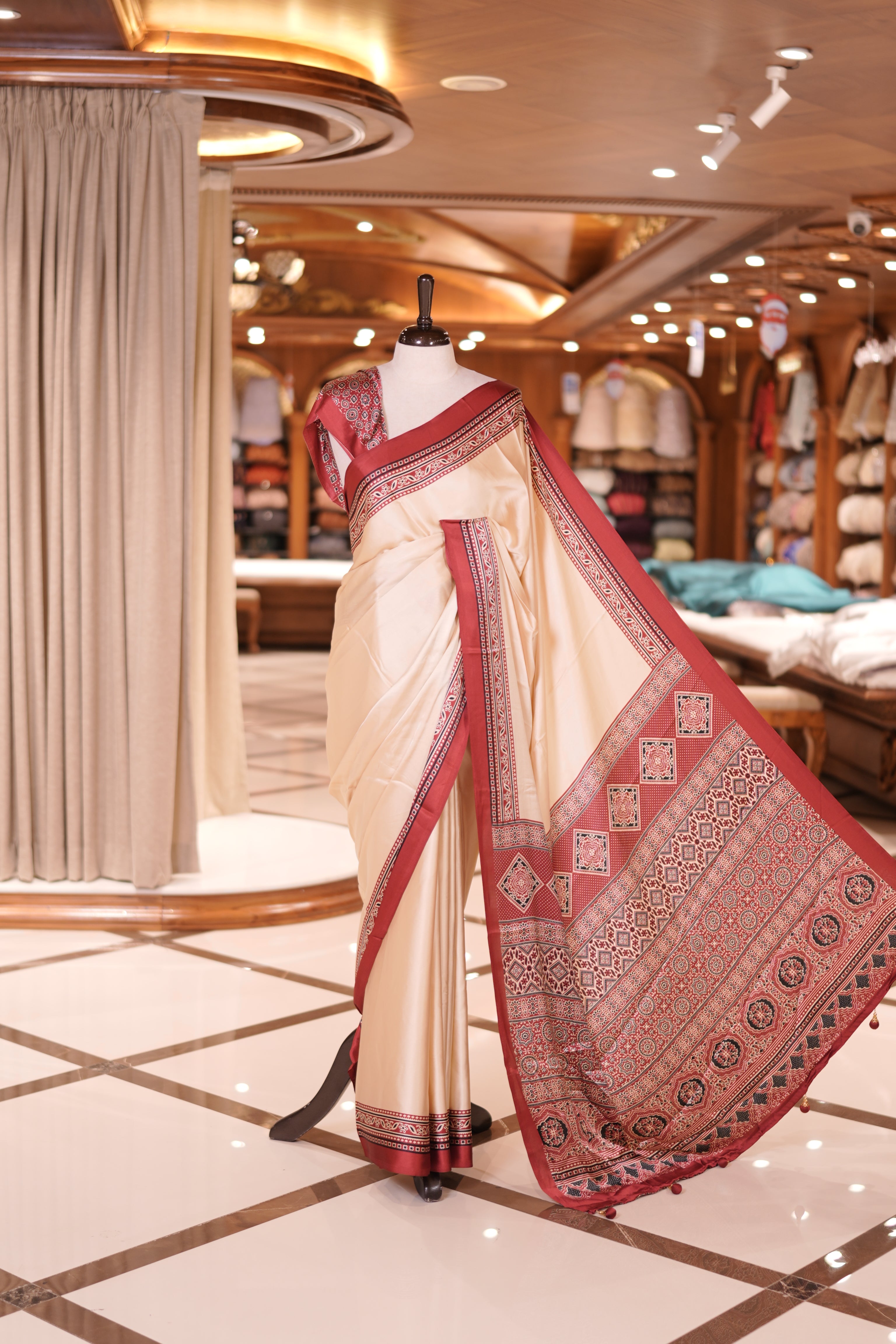 Cream colour semi modal saree featuring an elegant Maroon border with intricate woven designs and a richly detailed pallu, paired with a matching blouse